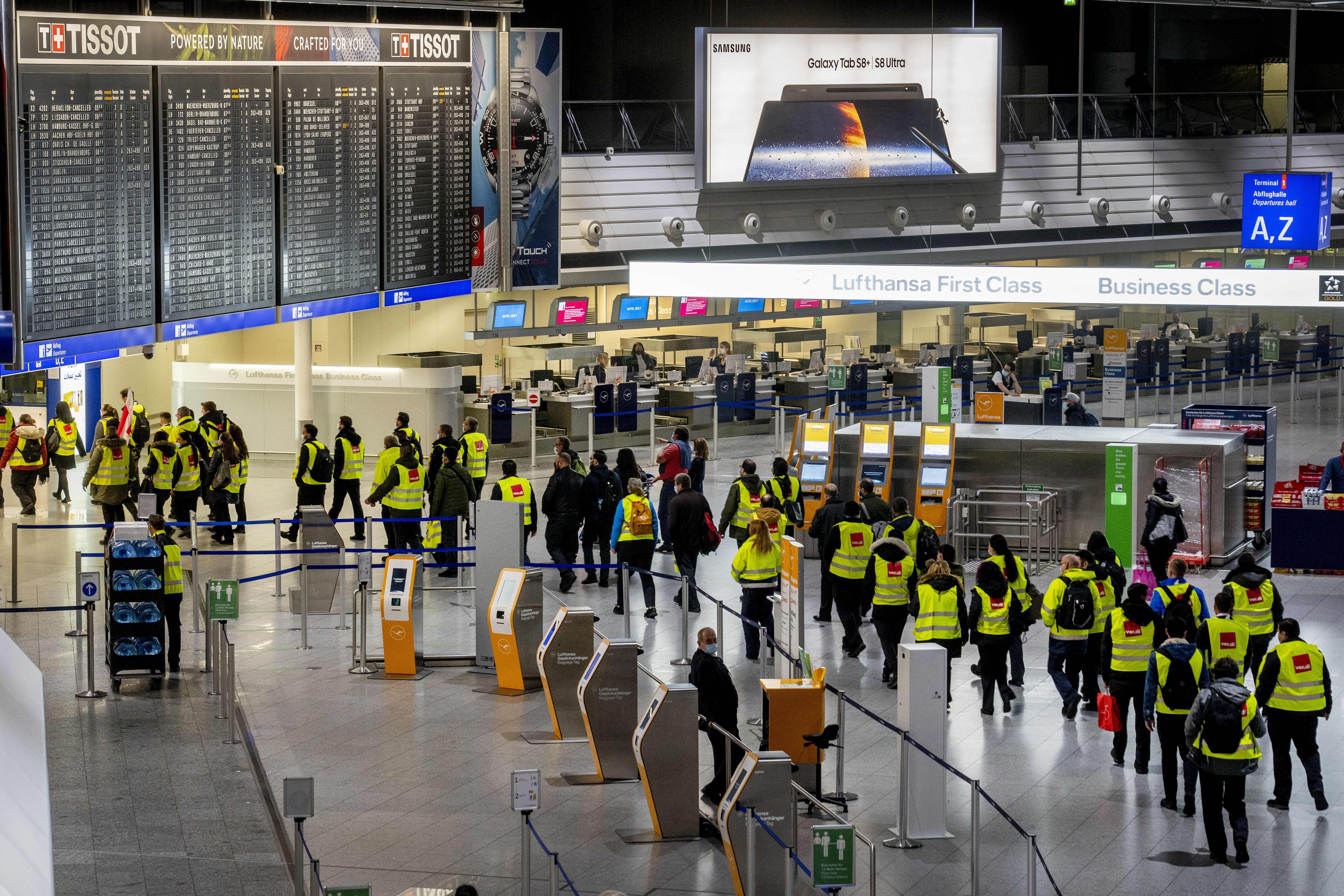 Security employees who control the flow of passengers and luggage walk through a terminal at the airport during a one day strike in Frankfurt