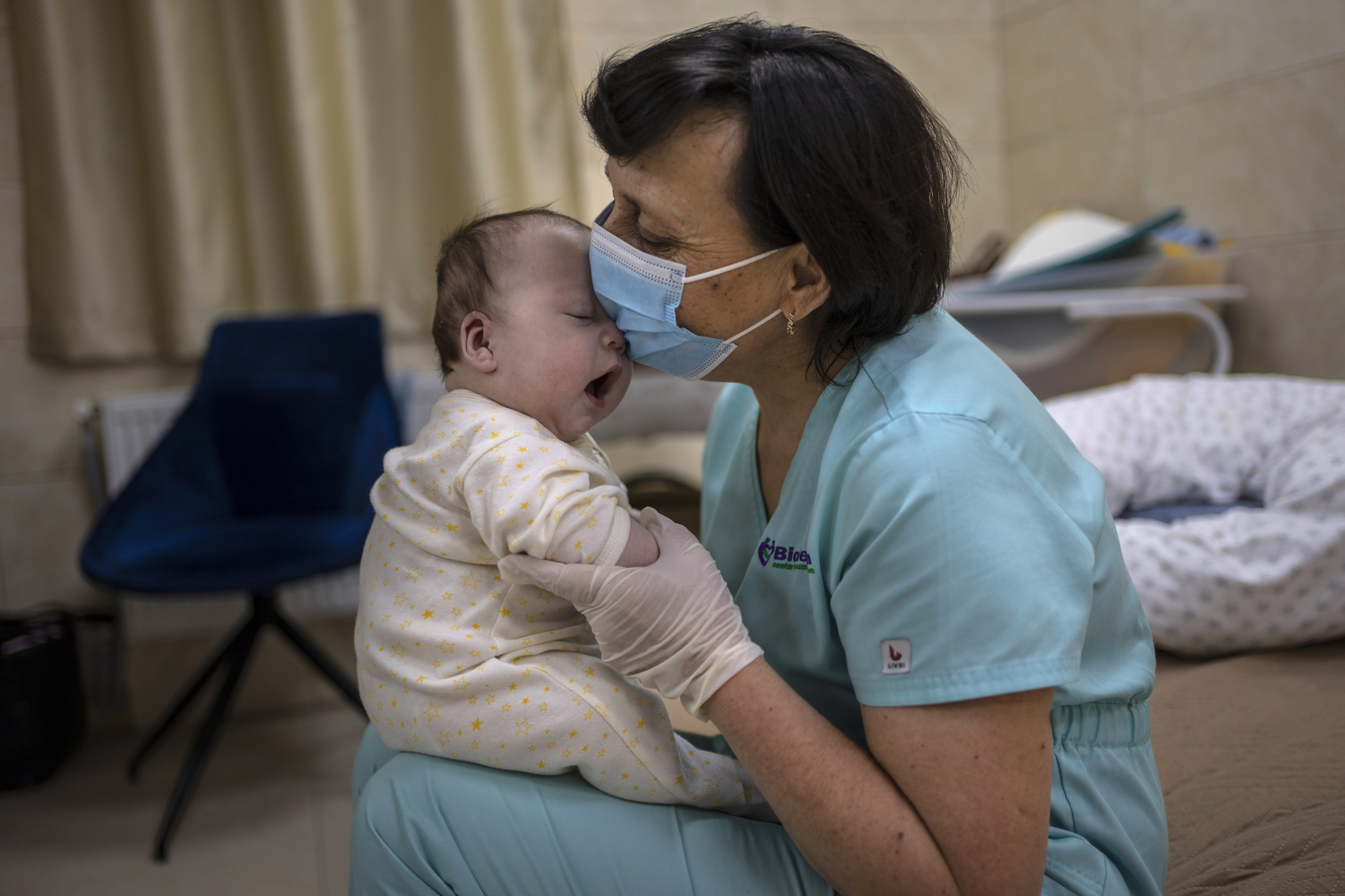 Nanny Svitlana Stetsiuk plays with one of the babies in the nursery in Kyiv