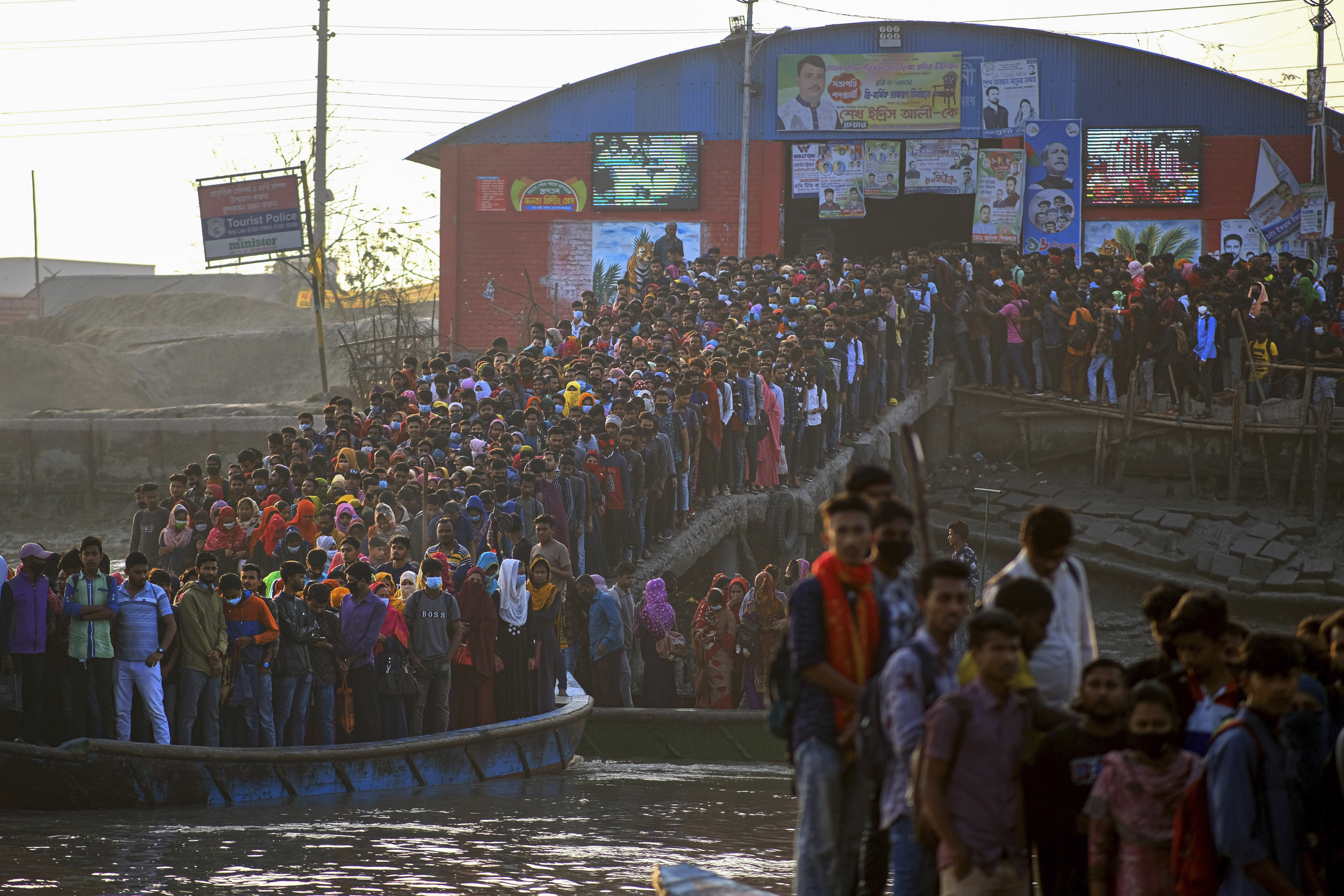 Workers gather in the morning at a boat terminal waiting to cross the Mongla river in Mongla