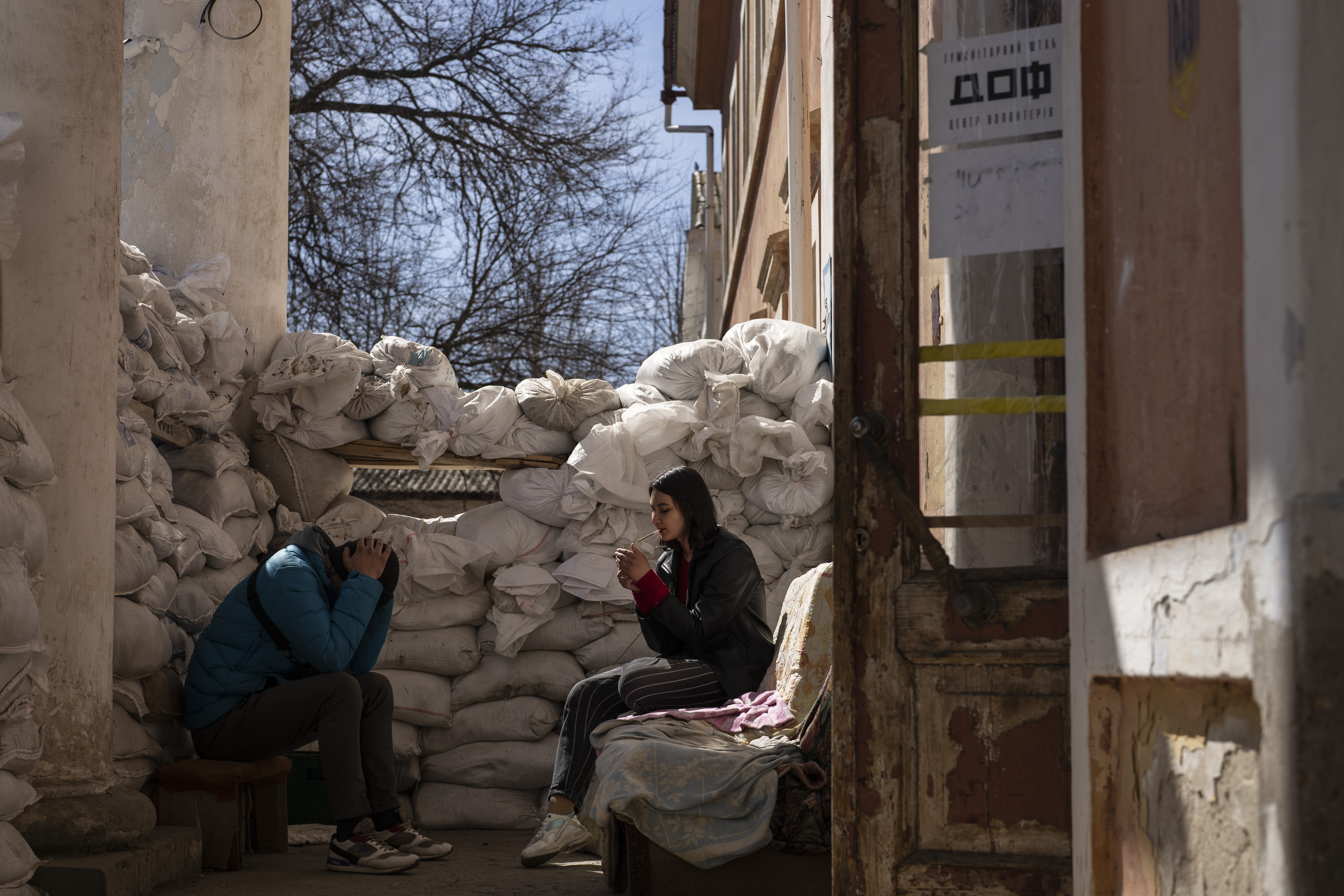 A volunteer smokes next to sandbags used for protection, at a Ukrainian volunteer center in Mykolaiv,