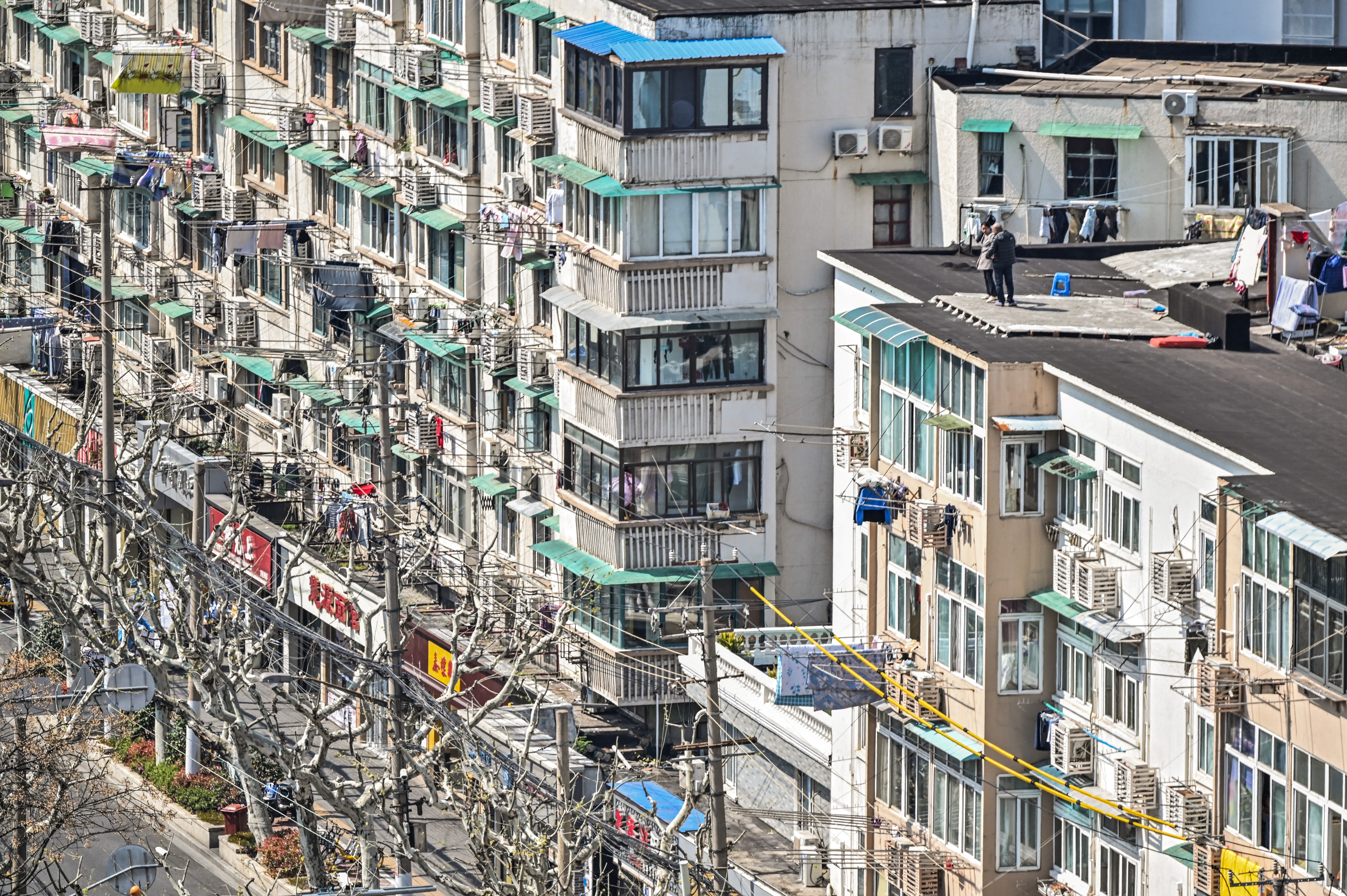 Densely packed, high rise apartments in locked down Shanghai with some people taking to the roof to get some fresh air