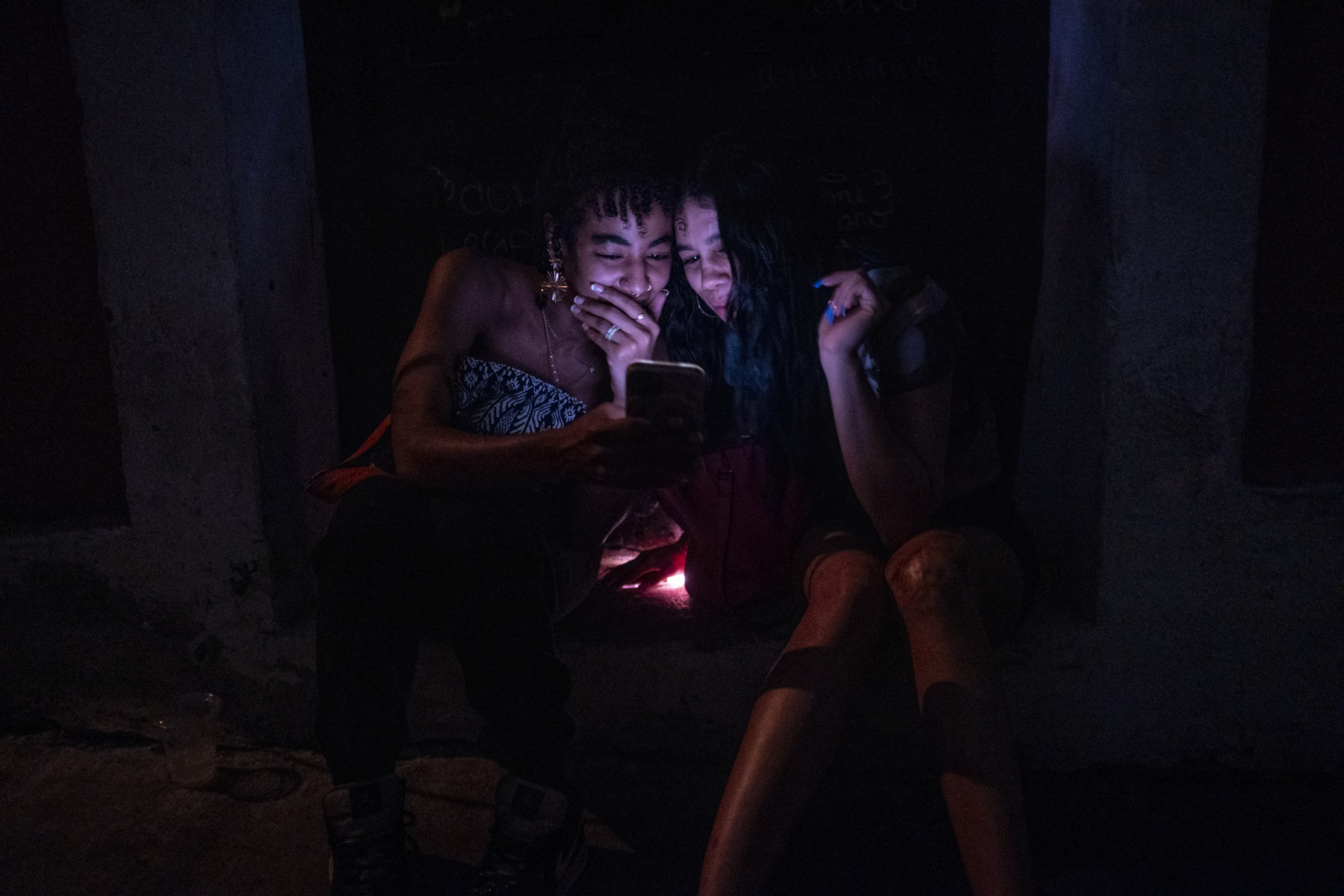 Two women look at a mobile phone in San Juan, Puerto Rico