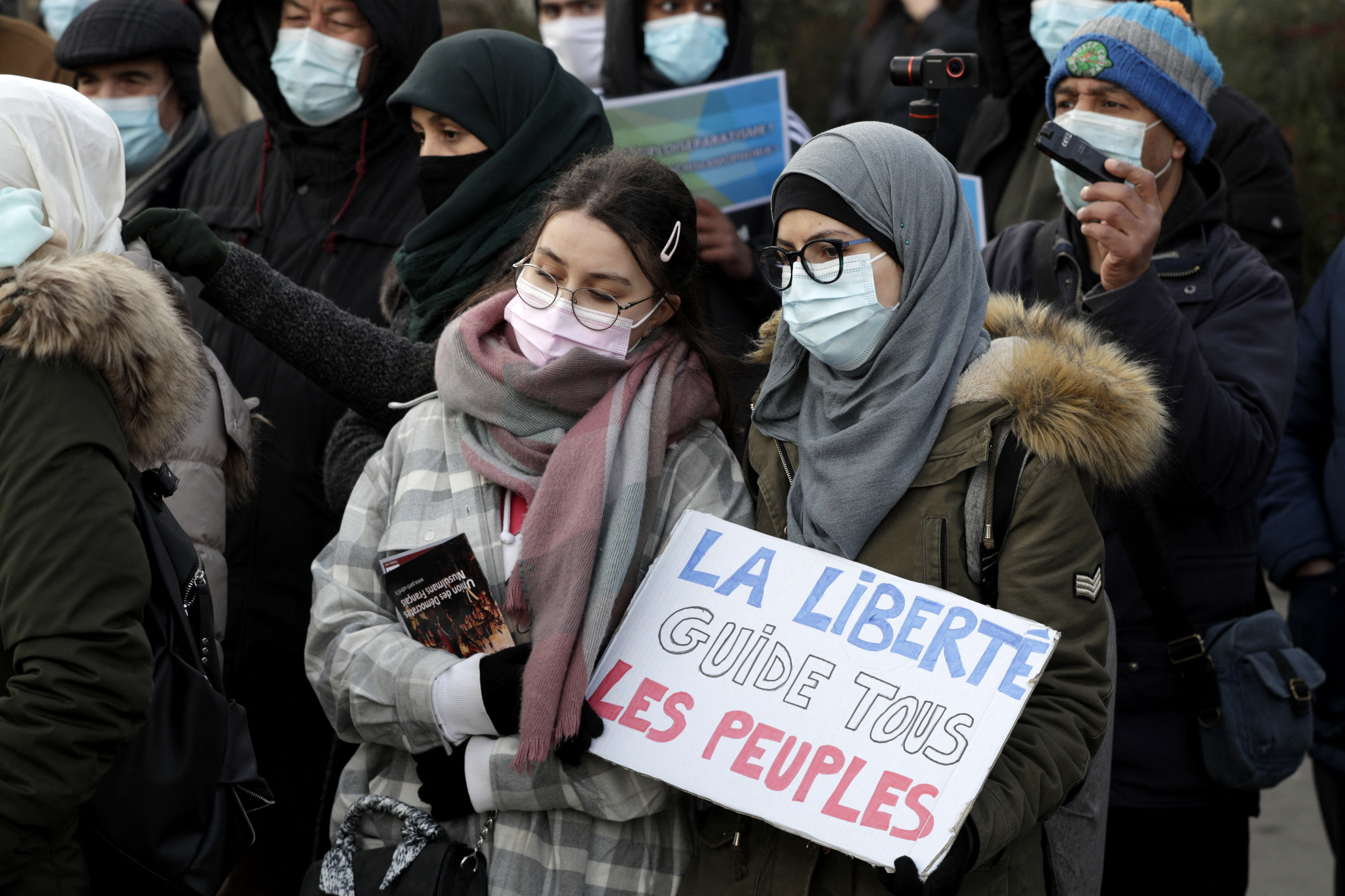 A woman holds a placard reading "Freedom leads all the people"