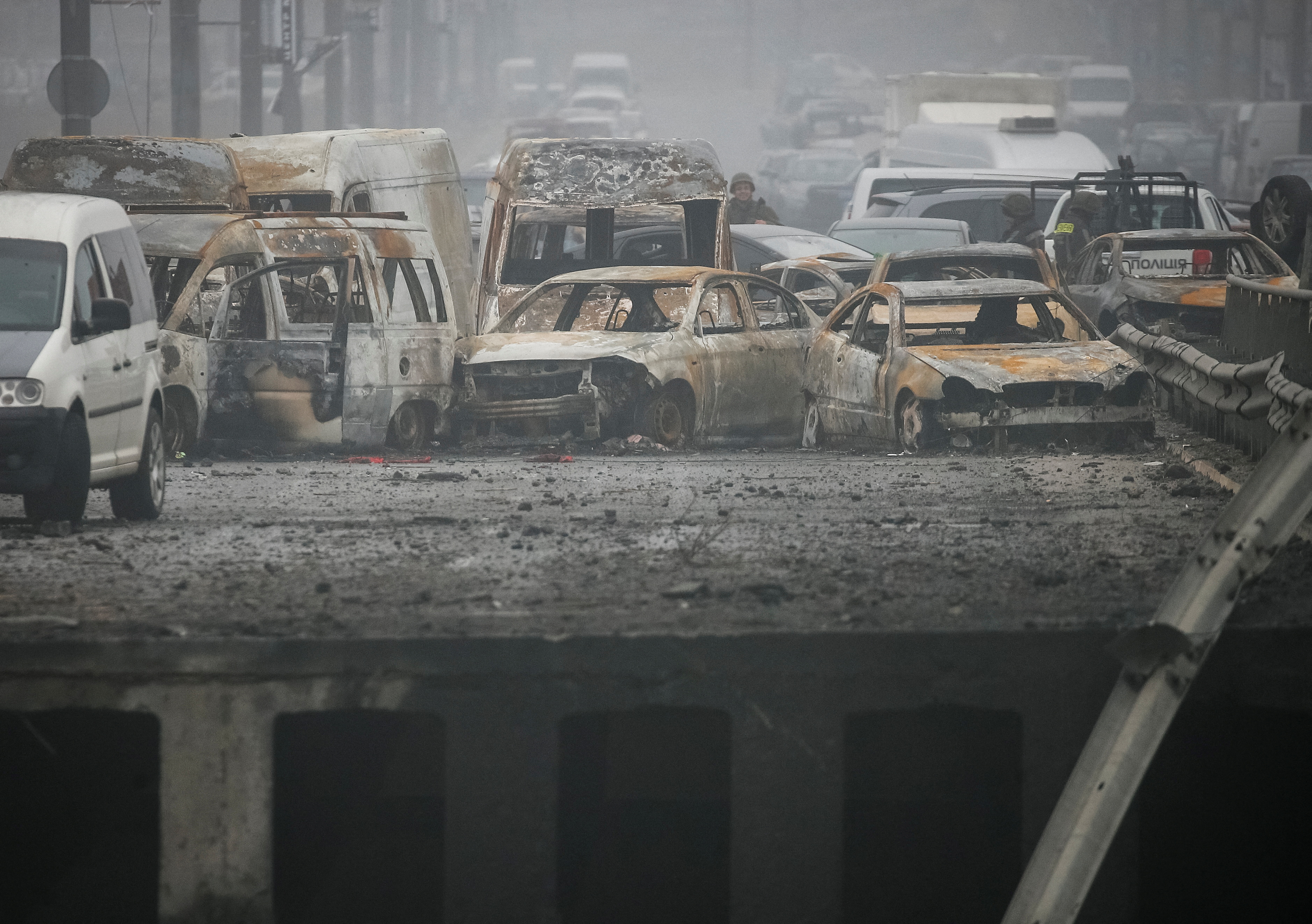 Сars burnt out from the shelling are seen on the destroyed bridge in Irpin town, amid Russia's invasion of Ukraine, outside of Kyiv