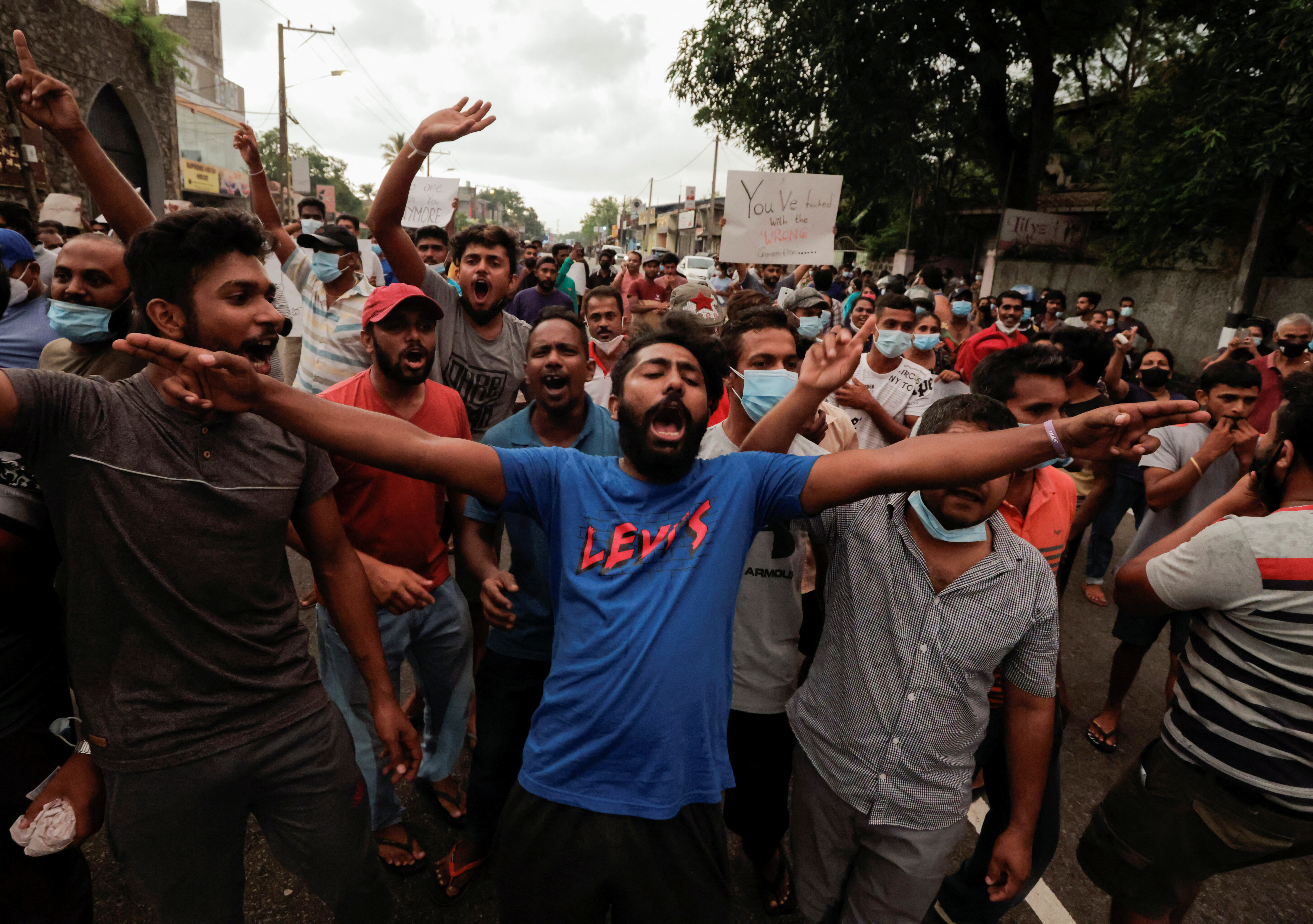 People shout slogans against Sri Lankan President Gotabaya Rajapaksa in a residential area of Colombo after the government imposed a curfew