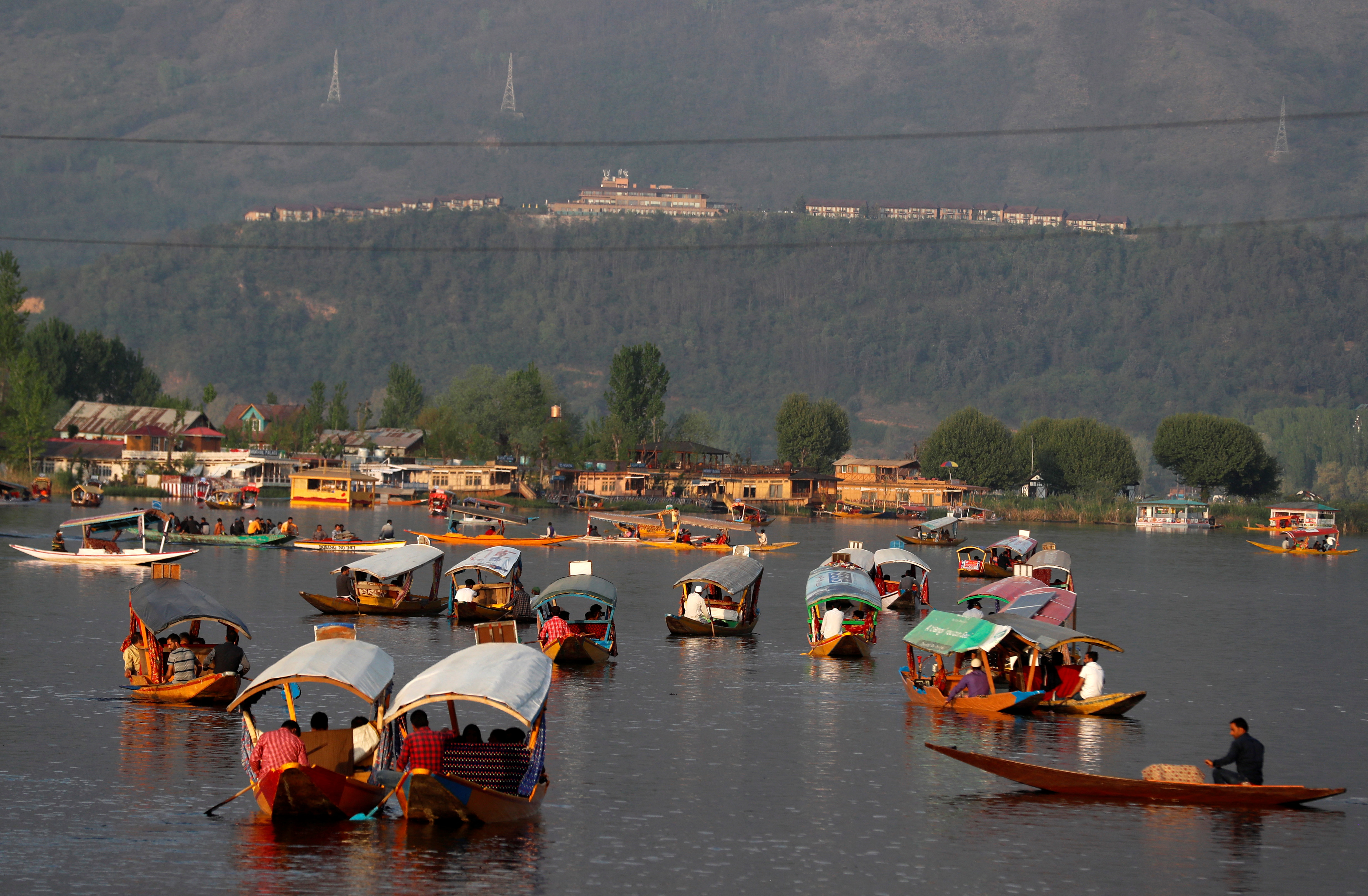 Tourists ride "Shikaras" or boats in the waters of Dal Lake