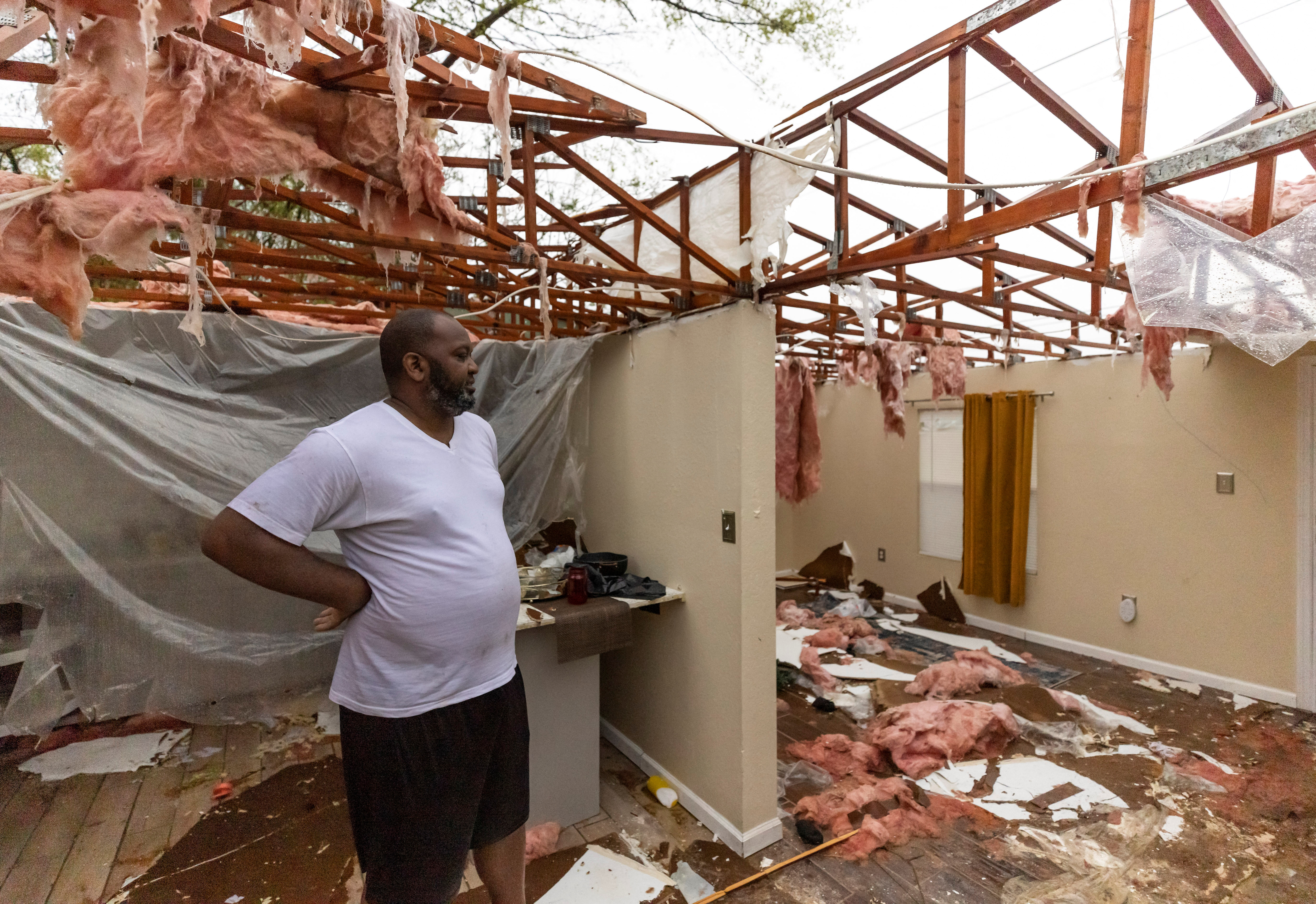 Thomas Cohen looks at the damage caused to his house after a tornado passed through the area in Allendale, South Carolina.