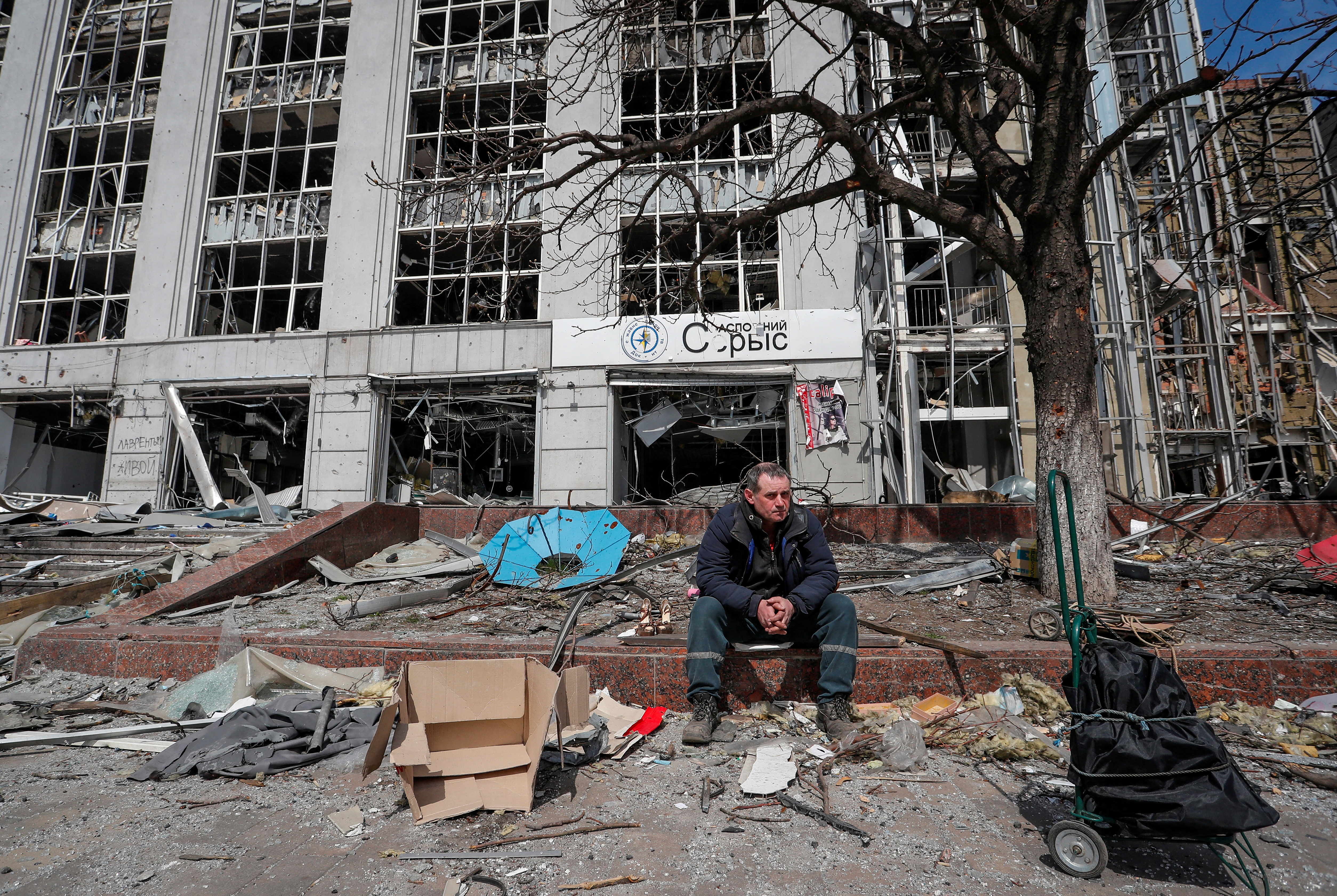 A resident looks on near a building destroyed in the course of the Ukraine-Russia conflict, in the southern port city of Mariupol, Ukraine April 10, 2022. REUTERS/Alexander Ermochenko TPX IMAGES OF THE DAY