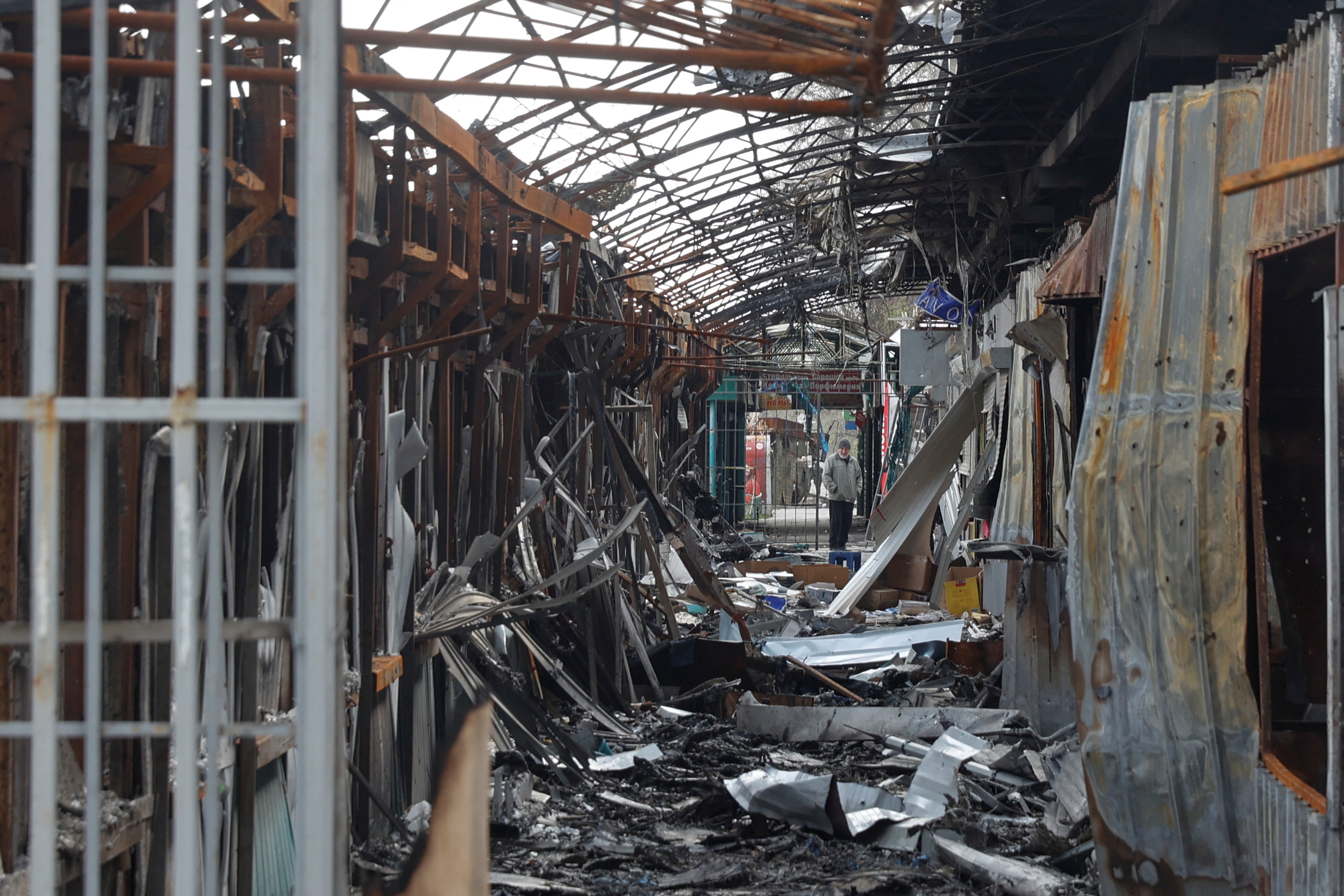 A local resident stands next to debris of an open market destroyed by a military strike, as Russia's attack on Ukraine continues, in Sievierodonetsk, Luhansk region, Ukraine