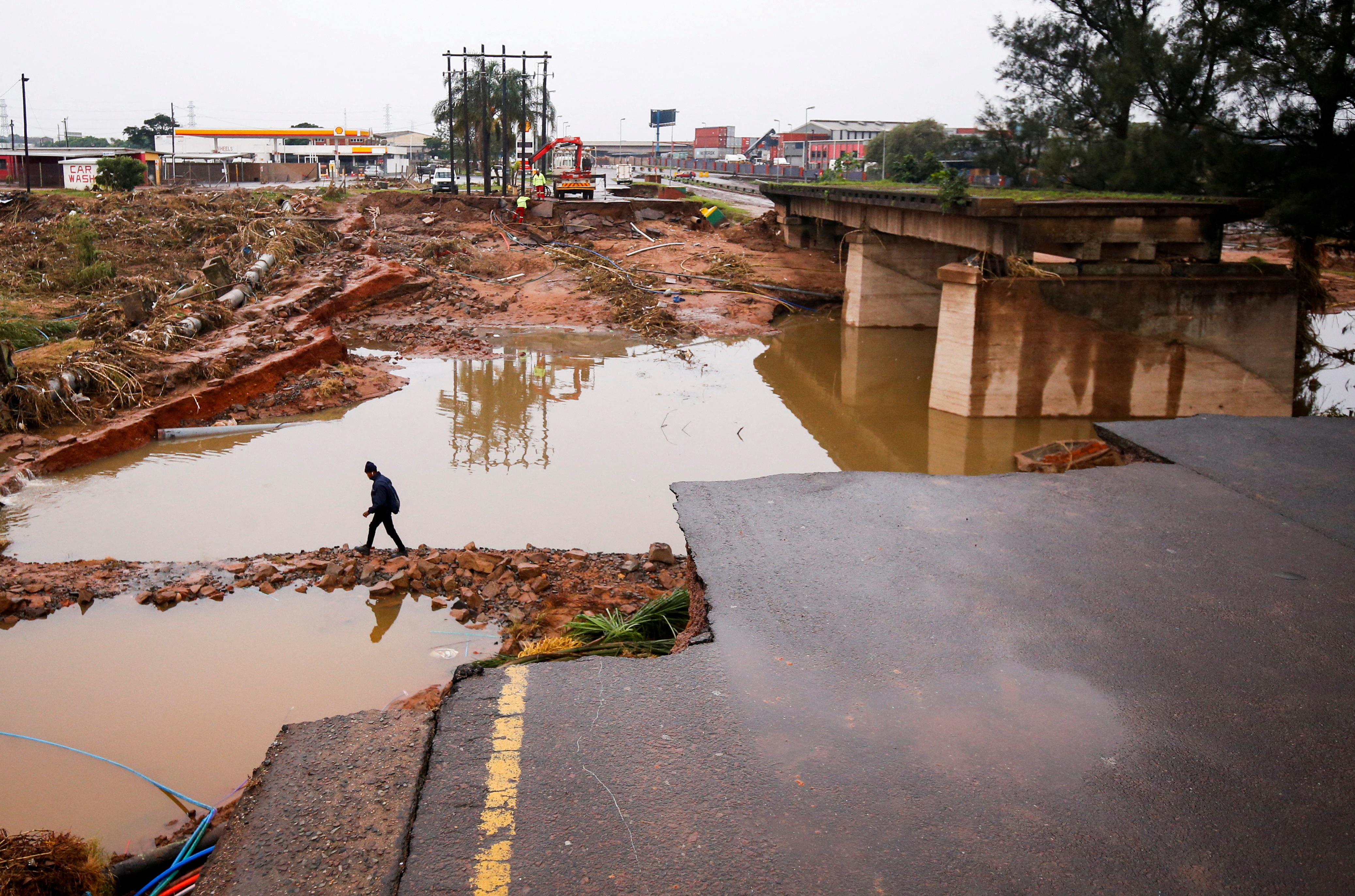 A man walks around a damaged bridge caused by flooding in Umlazi near Durban, South Africa, April 16, 2022. 