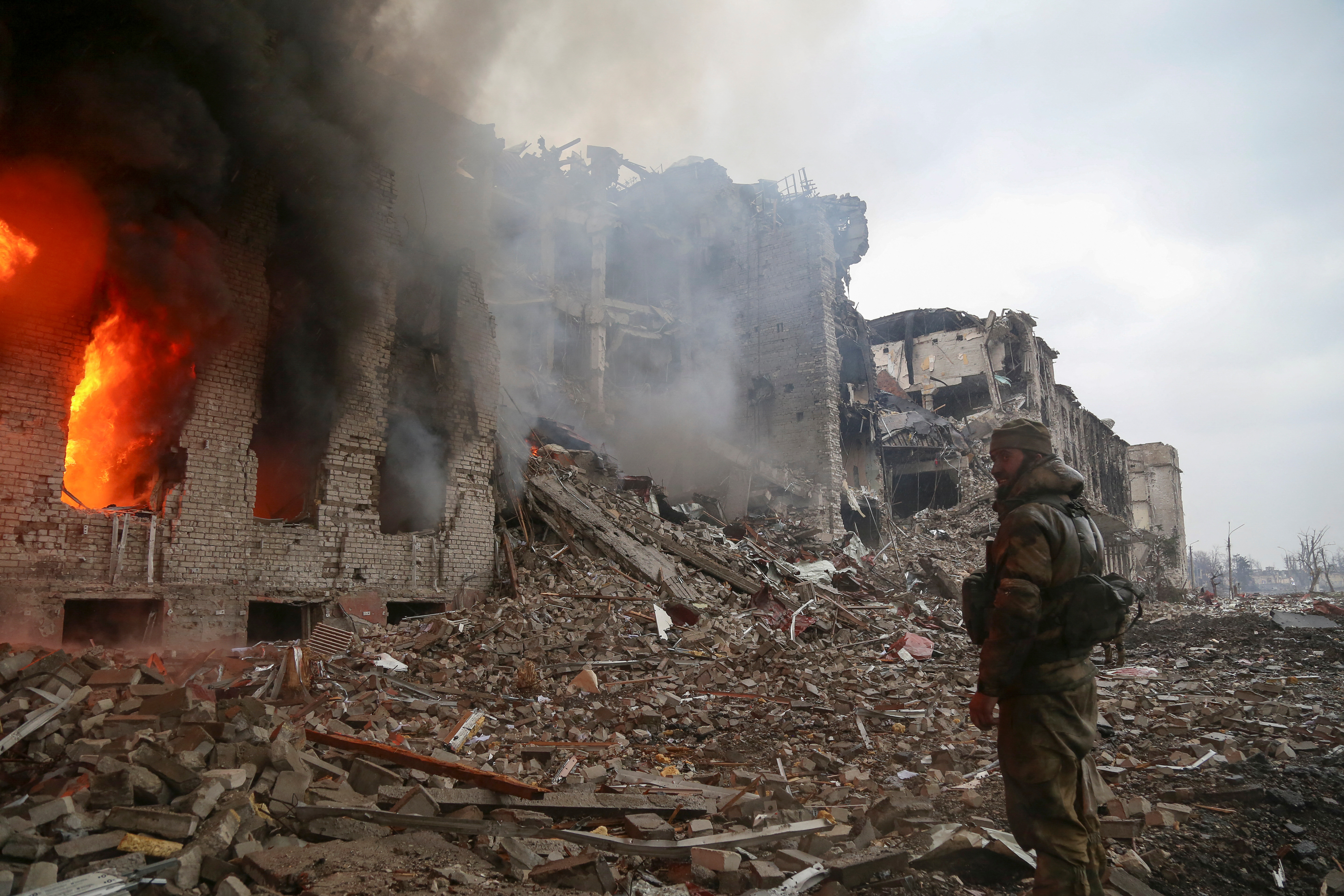 A service member of pro-Russian troops stands in front of the destroyed administration building of Azovstal Iron and Steel Works during Ukraine-Russia conflict