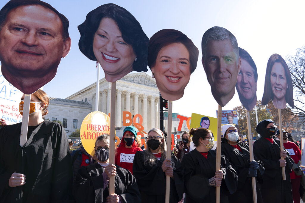 Abortion rights advocates holding cardboard cutouts of the Supreme Court Justices, demonstrate in front of the U.S. Supreme Court.