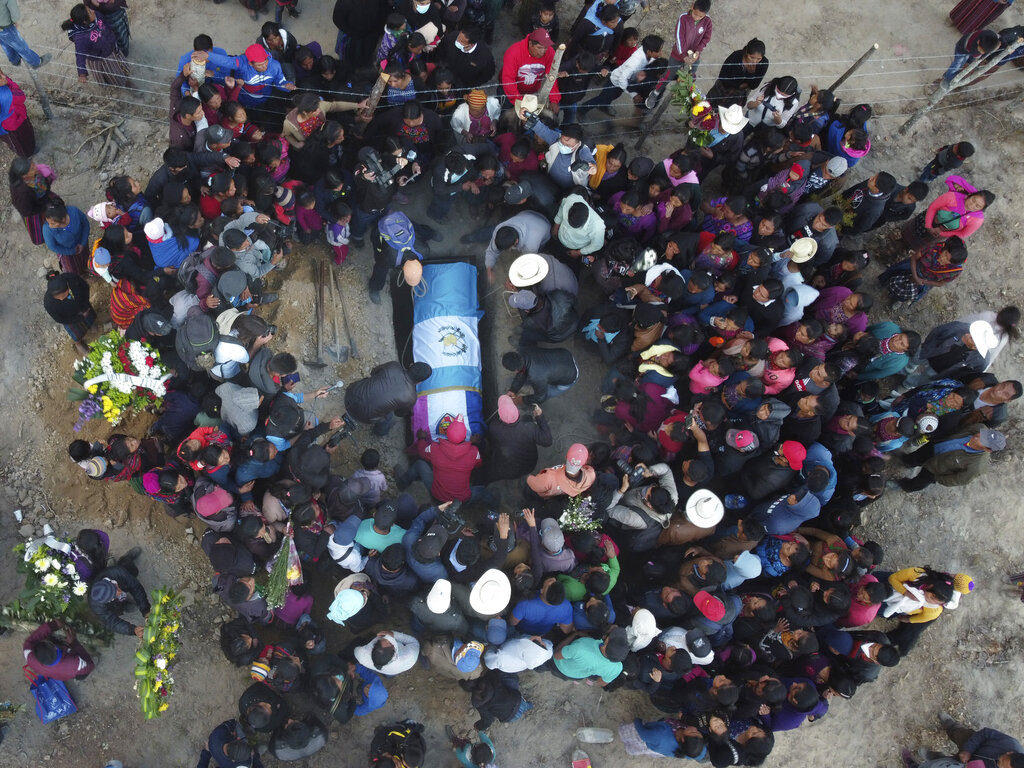 People lower the remains of Elfego Miranda Diaz into a grave, one of the Guatemalan migrants who was killed near the U.S.-Mexico border.