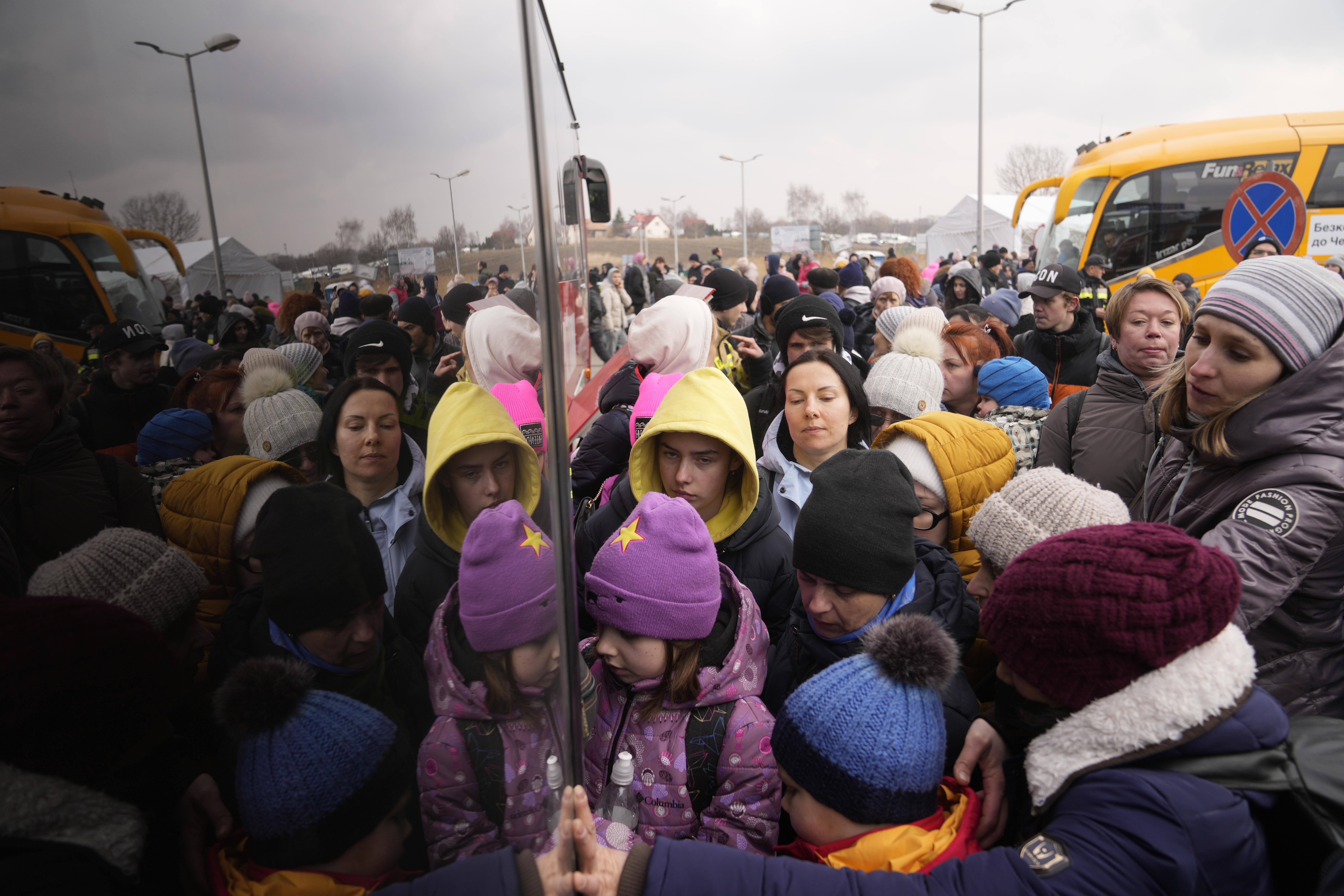 People fleeing from Ukraine queue to board a bus at the border crossing in Medyka, Poland on March 4, 2022