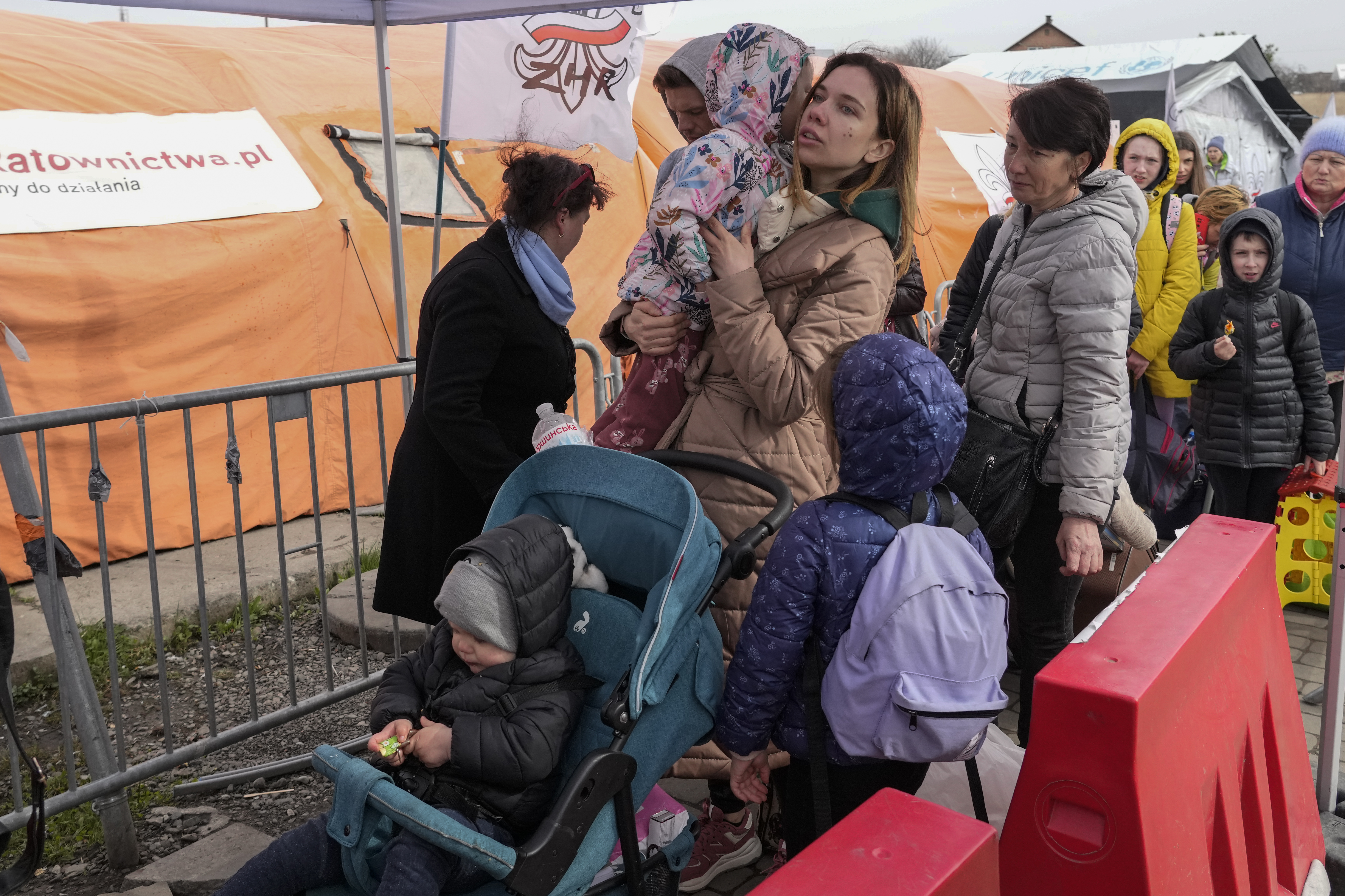 Refugees wait in a line after fleeing the war from neighboring Ukraine at the border crossing in Medyka, southeastern Poland, Sunday, April 10, 2022.