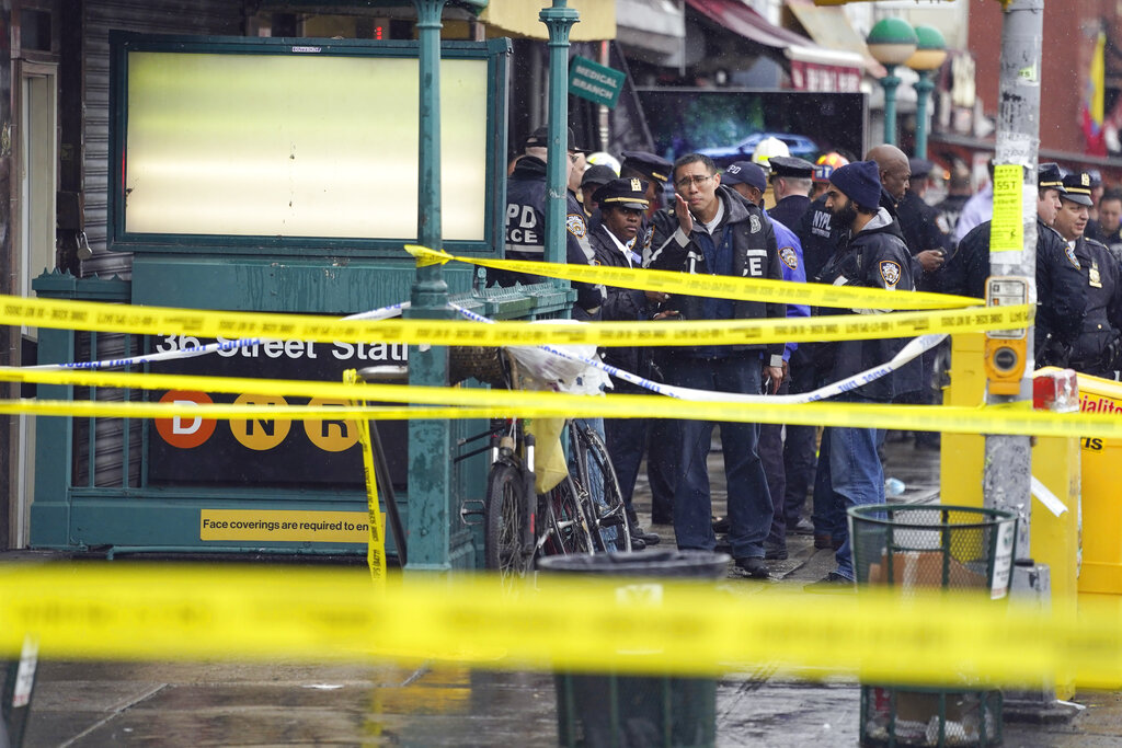 Yellow police tape blocks off the entrance to the subway as New York City Police Department personnel gather at the entrance to a subway stop in the Brooklyn borough of New York.