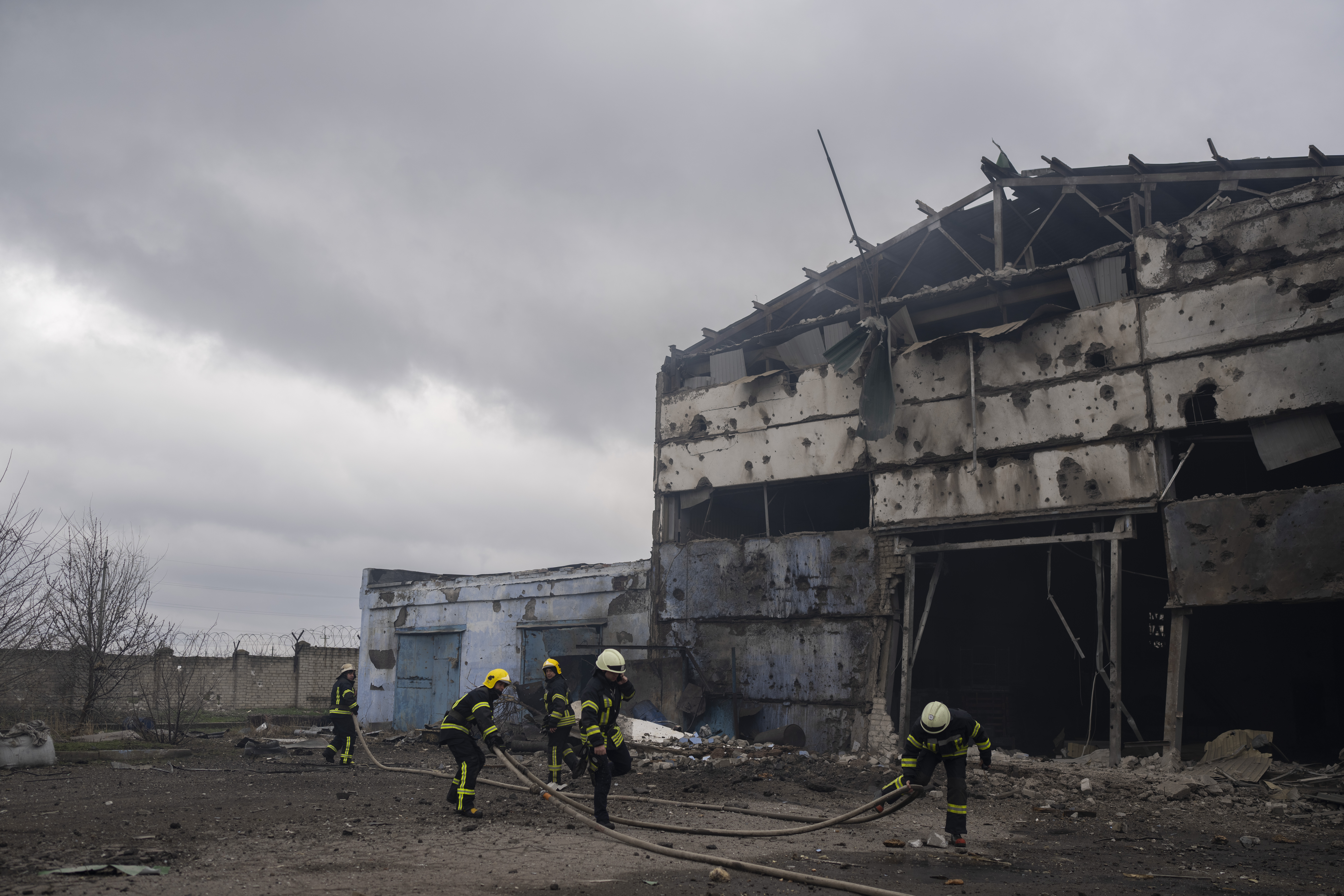 Firefighters try to extinguish the fire at a damaged factory
