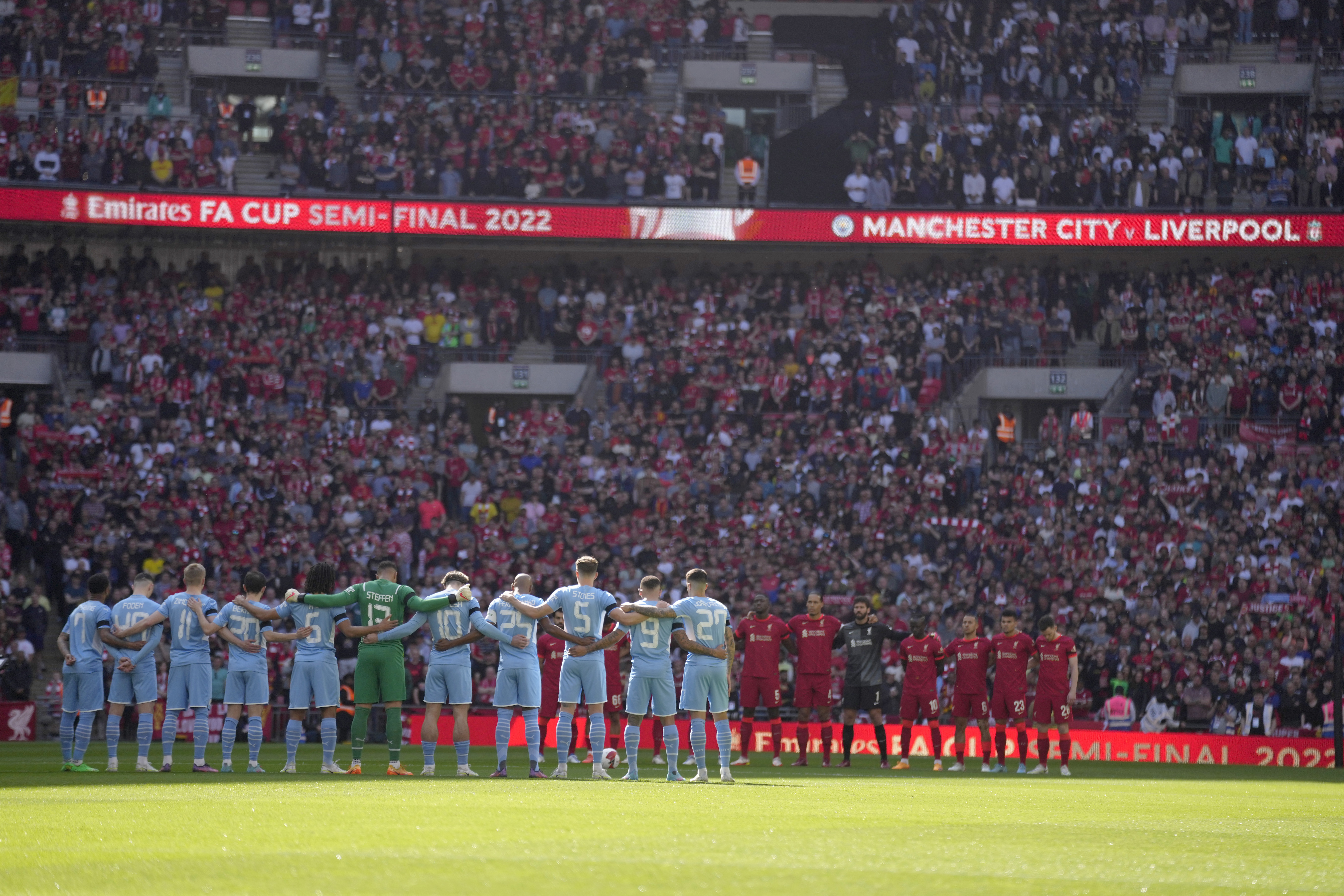 Manchester City, left, and Liverpool players stand for a moment of silence to remember those who died in the 1989 Hillsborough disaster