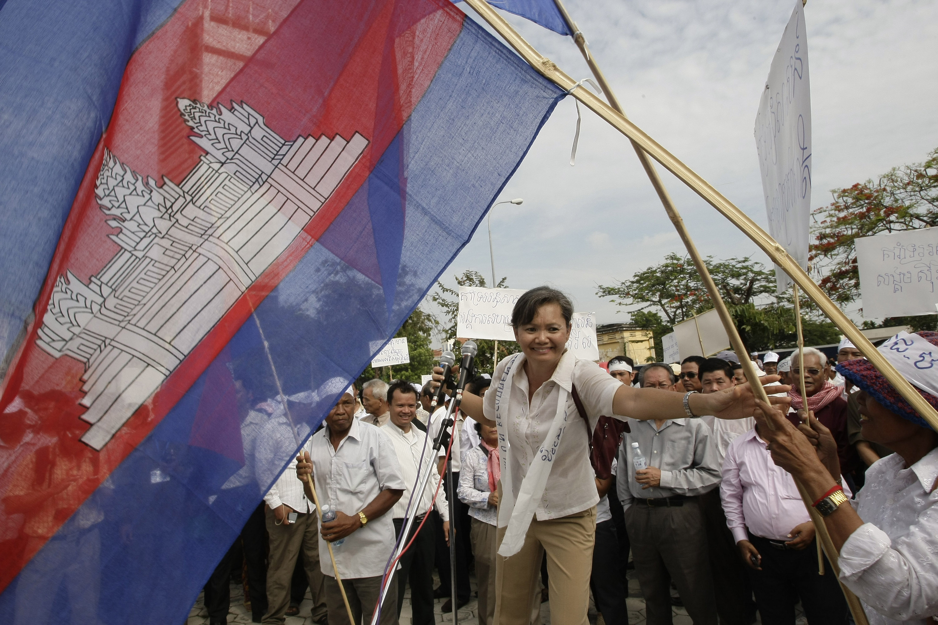 Mu Sochua holds a Cambodian flag as she takes part in a rally following the 2013 elections
