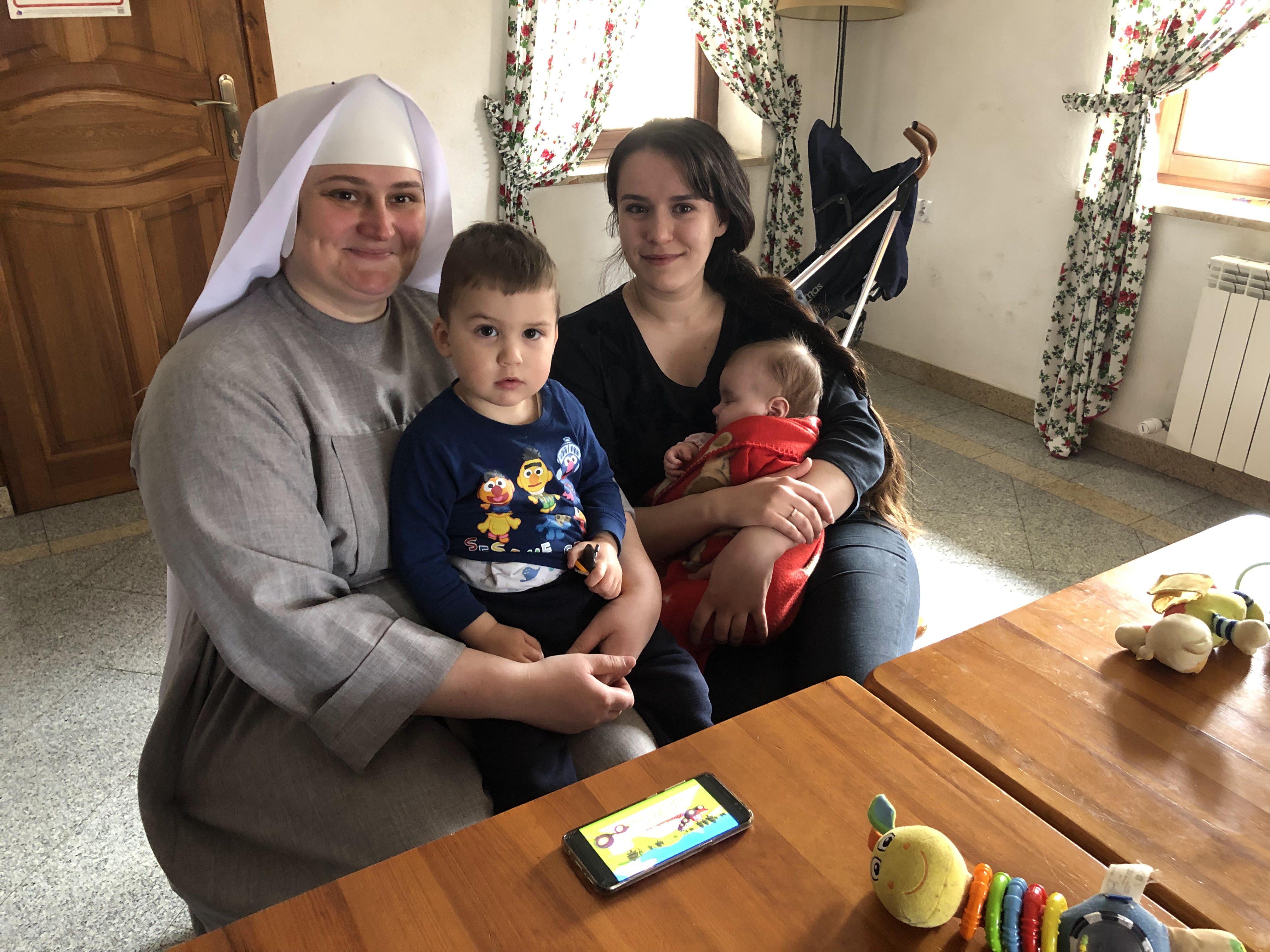 A photo of two women, Diana Oliynyk and Monika Chernyeska, holding two children, Yeva and Marko.