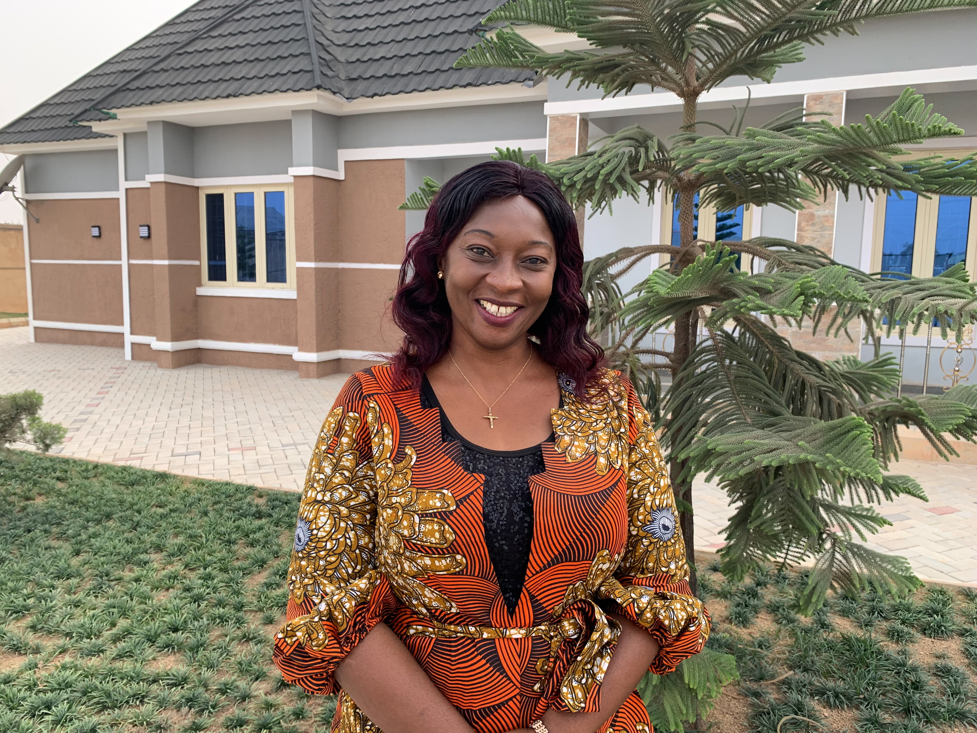 A woman stands in front of a building