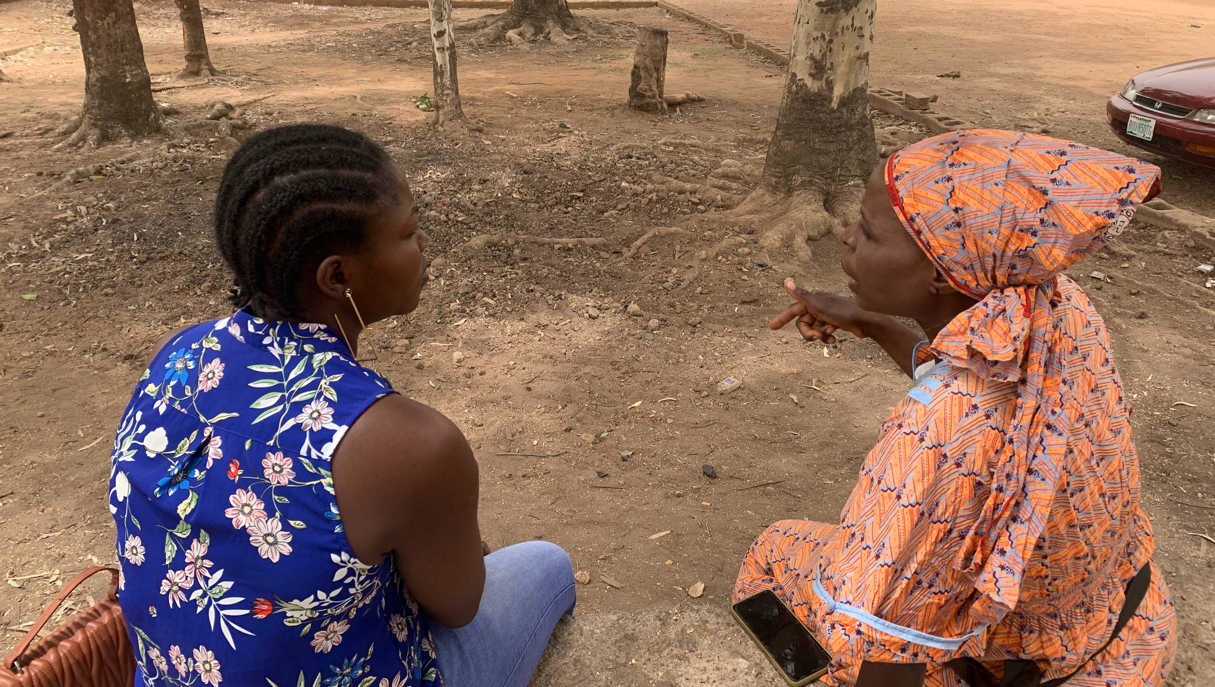 Two women sit outside and talk