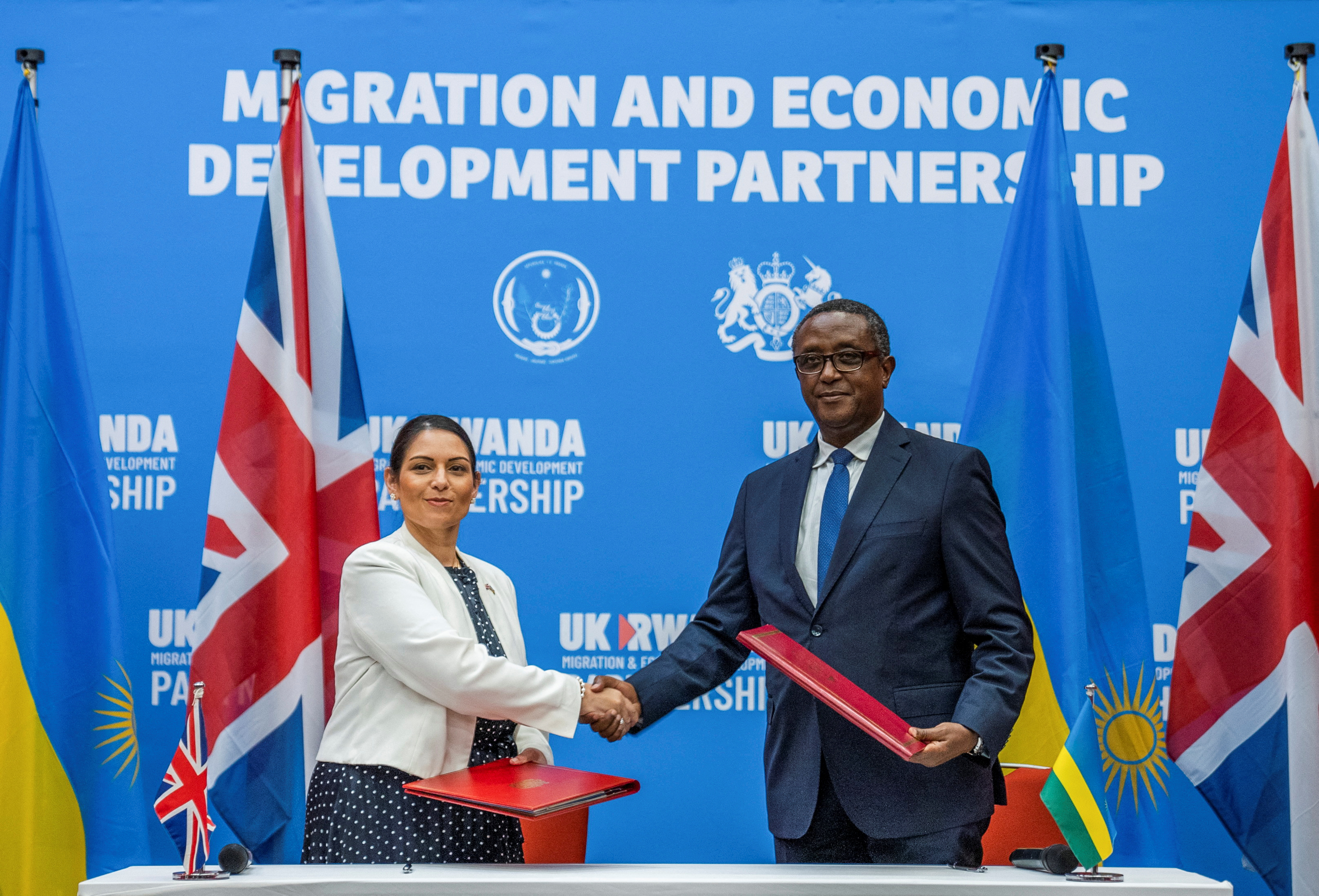 British Home Secretary Priti Patel shakes hands with Rwandan Foreign Minister Vincent Birutaare