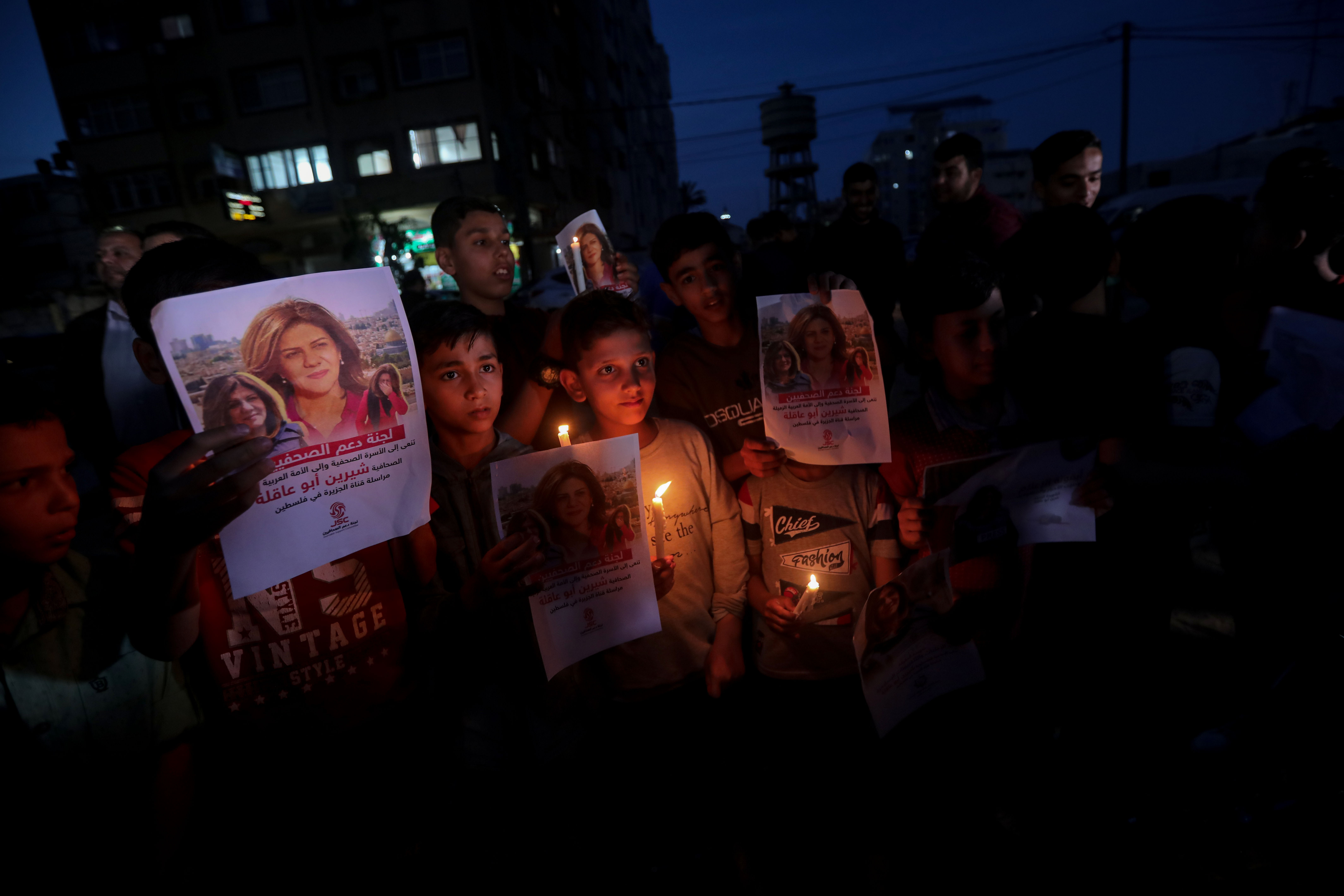 Children light candles mourning the killing of Shireen Abu Akleh