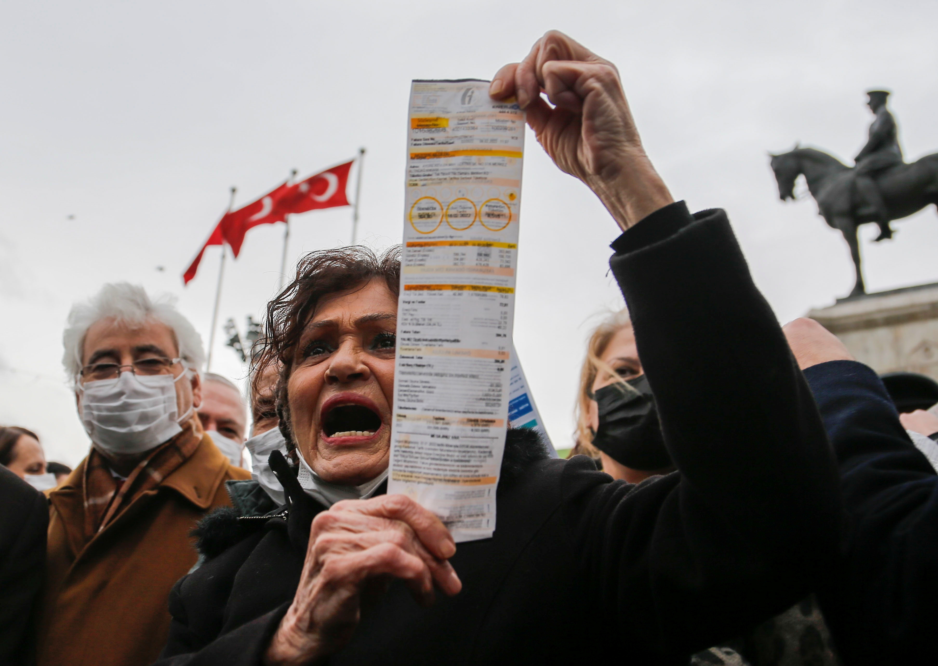 A woman displays her electricity bill during a protest against high energy prices in Ankara, Turkey February 9, 2022.