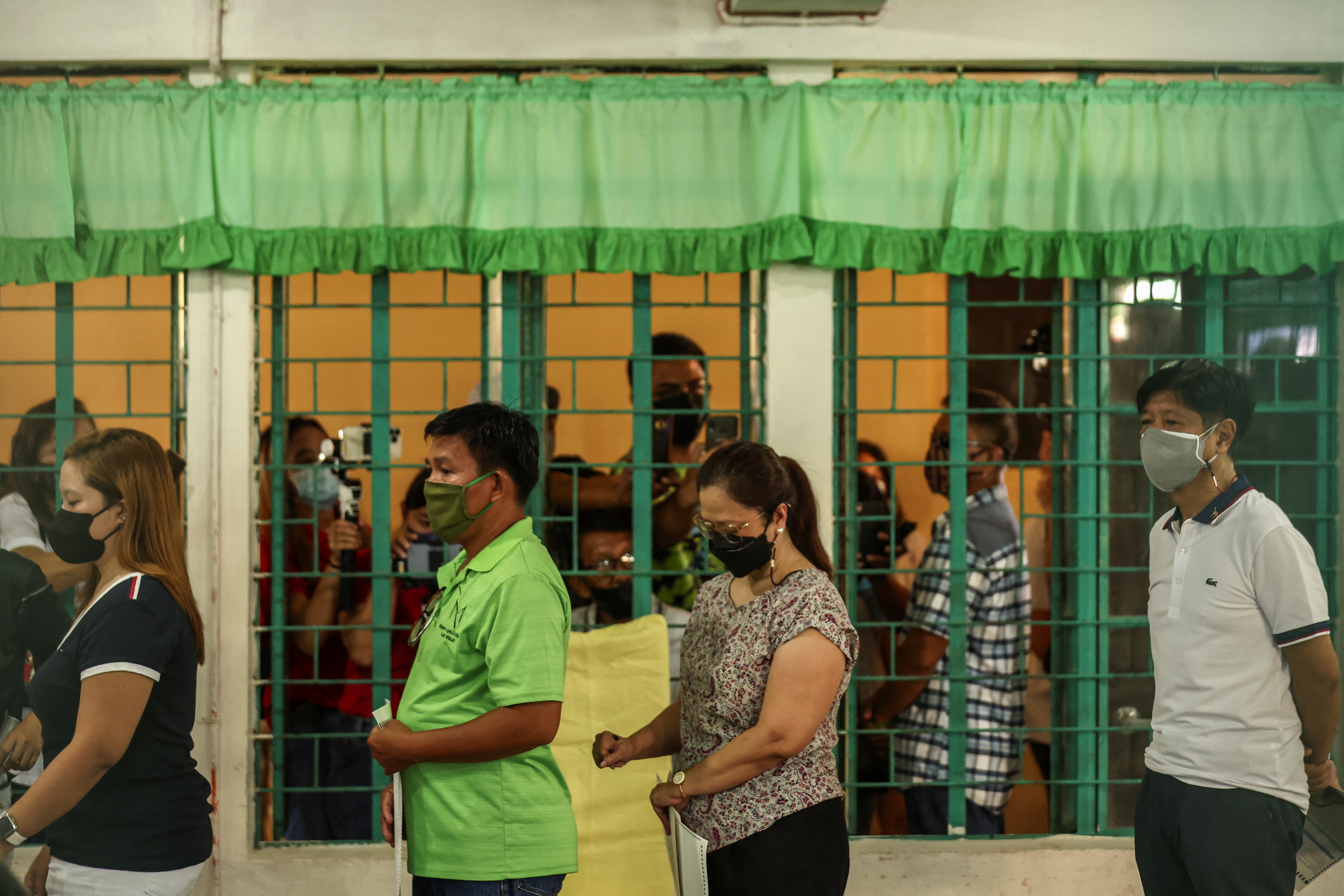 Presidential aspirant Ferdinand "Bongbong" Marcos Jr., the son and namesake of the late dictator, casts his vote in the 2022 national elections at Mariano Marcos Memorial Elementary School, in Batac, Ilocos Norte,