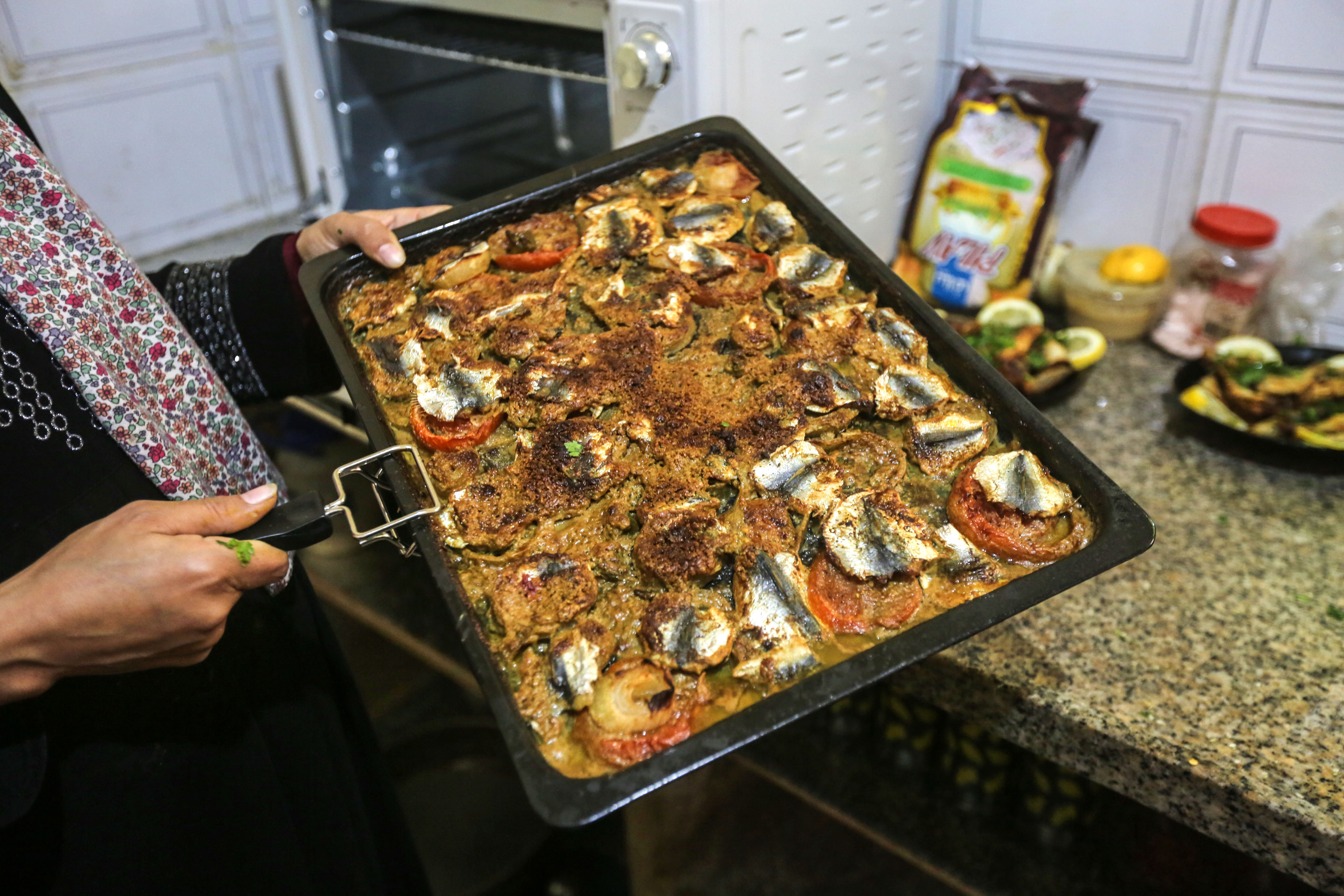 Madelyn pulls the finished tahini-baked sardines out of the oven
