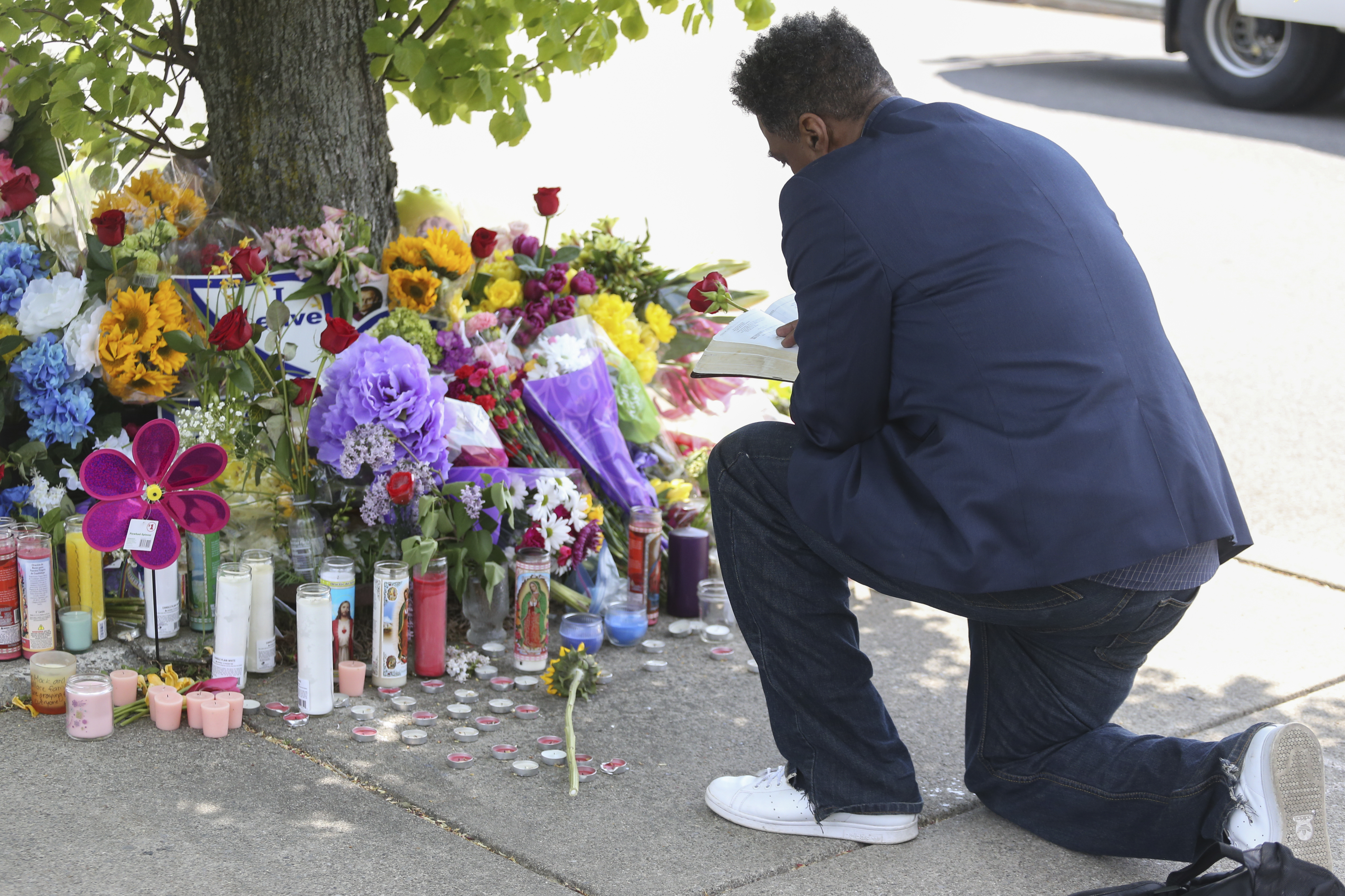 A man reads scripture at the site of a memorial