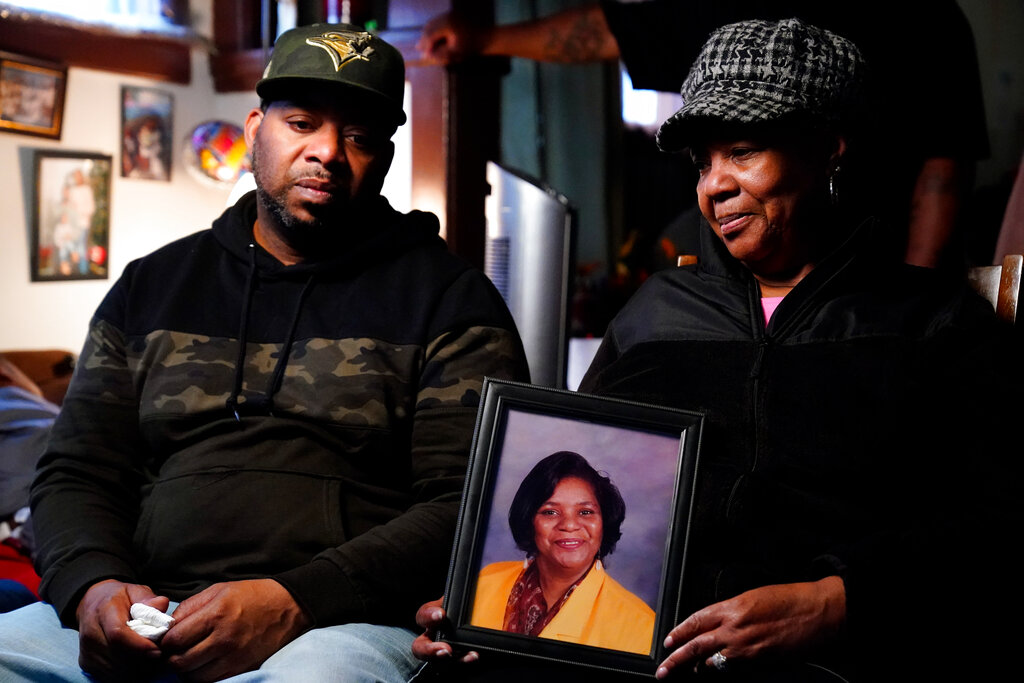 Wayne Jones, left, looks on as his aunt JoAnn Daniels, holds a photograph of his mother Celestine Chaney, who was killed in Saturday's shooting at a supermarket in Buffalo, N.Y.