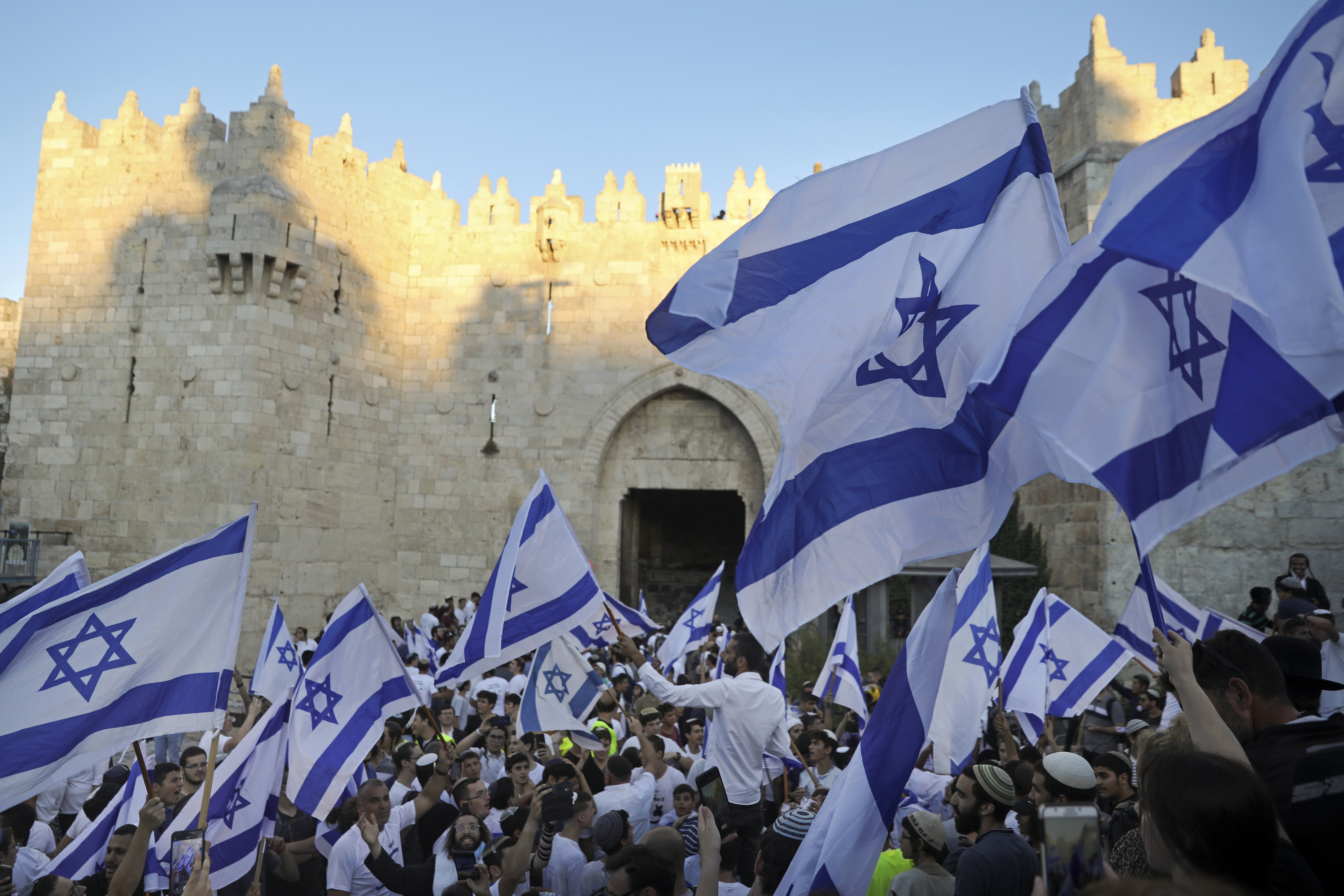 Jewish ultra-nationalists wave Israeli flags during the "Flags March," next to Damascus gate, outside Jerusalem's Old City, June 15, 2021.