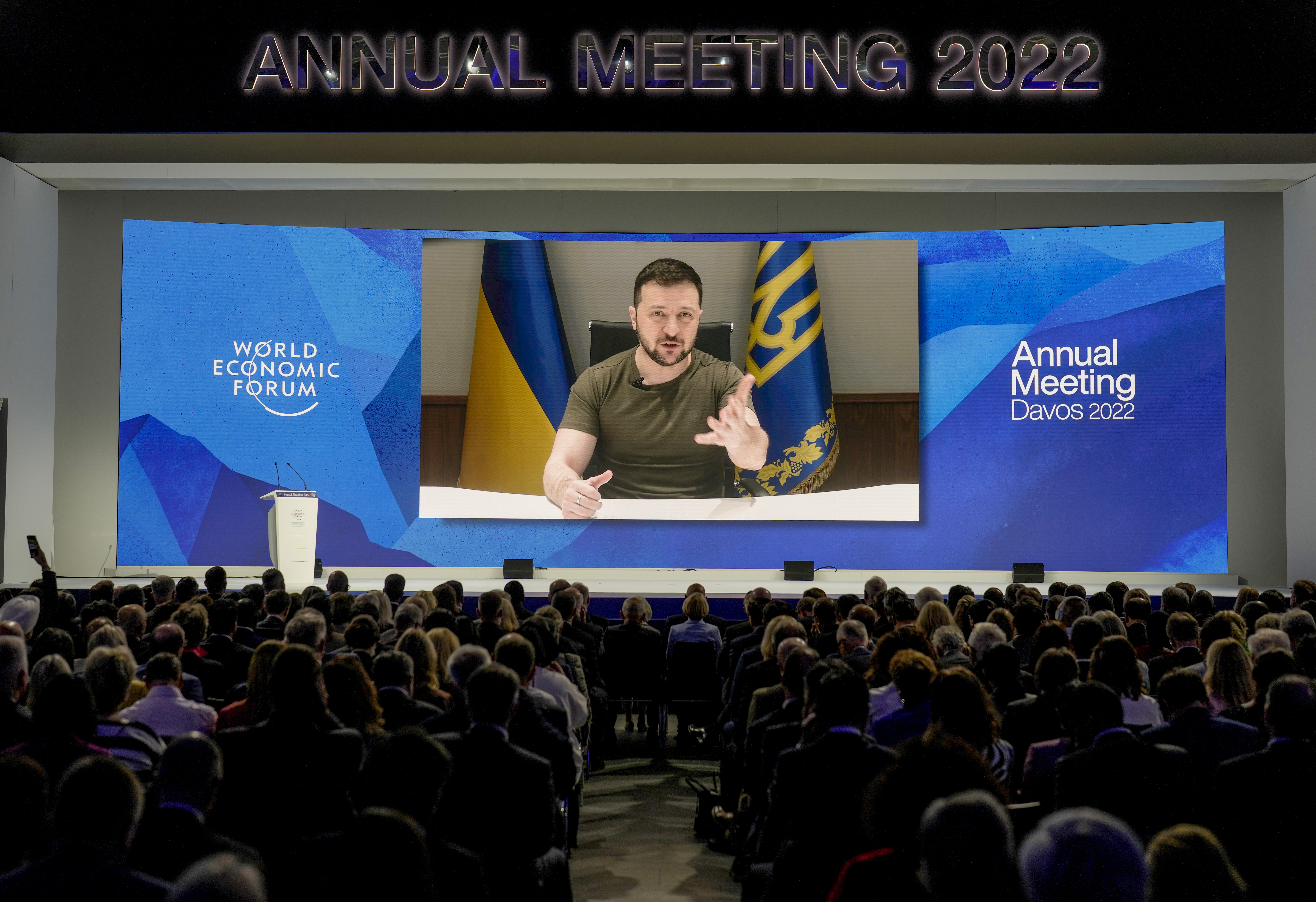 Ukrainian President Volodymyr Zelenskyy displayed on a screen as he addresses the audience from Kyiv on a screen during the World Economic Forum in Davos, Switzerland,