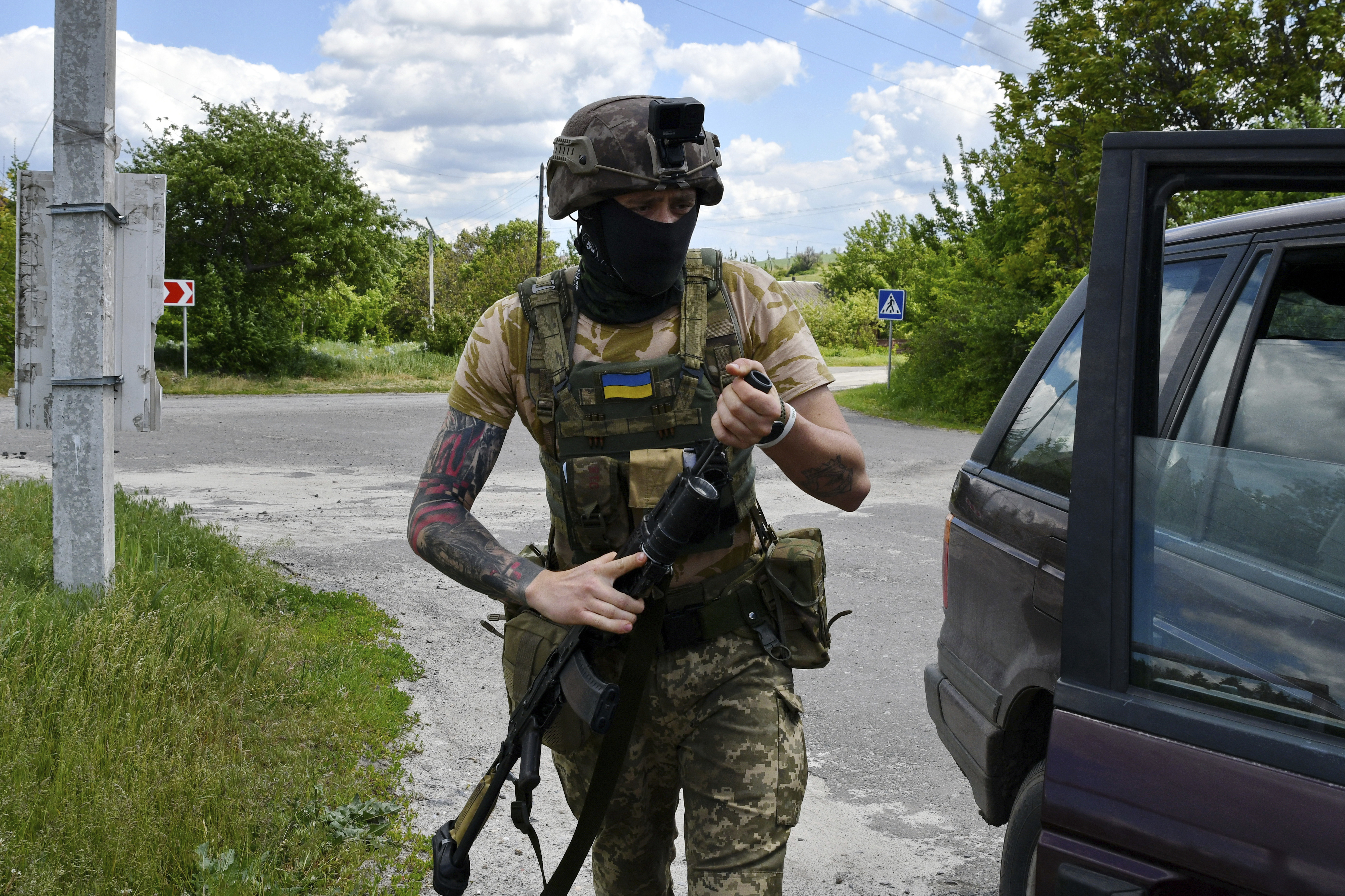 A Ukrainian serviceman boards a car in the village of Mayaky, Donetsk