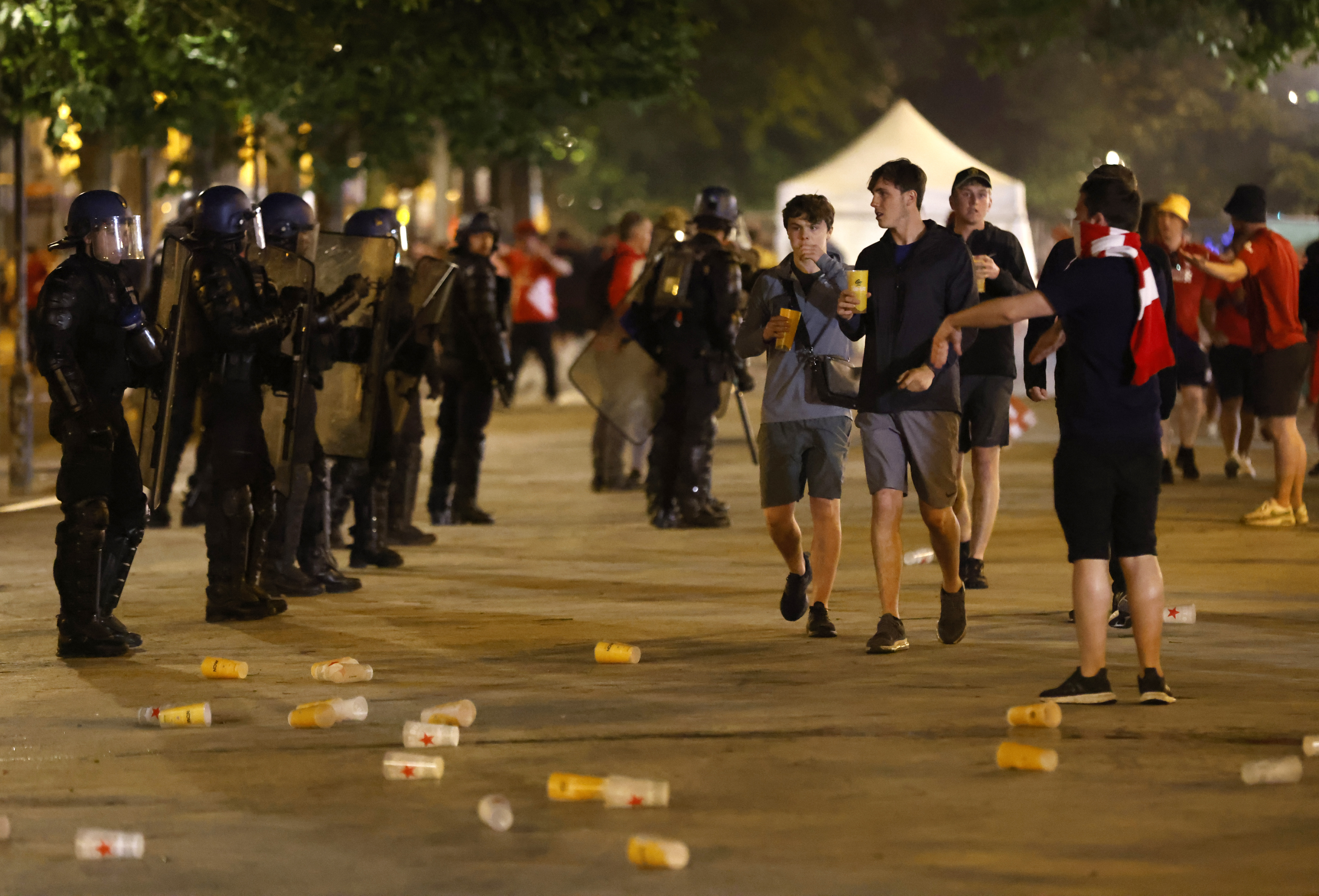Riot police watch Liverpool fans after the Champions League final soccer match between Liverpool and Real Madrid at a fan park in Paris