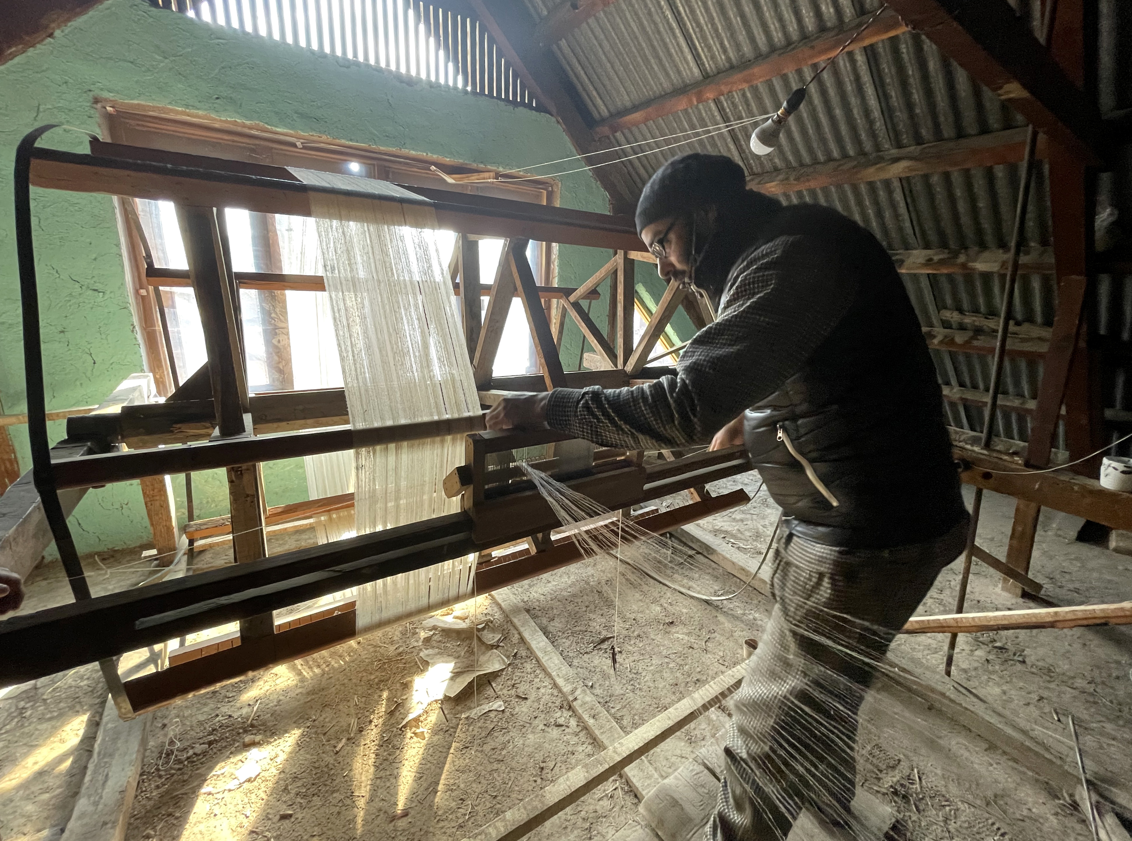 An artisan works on a traditional handloom