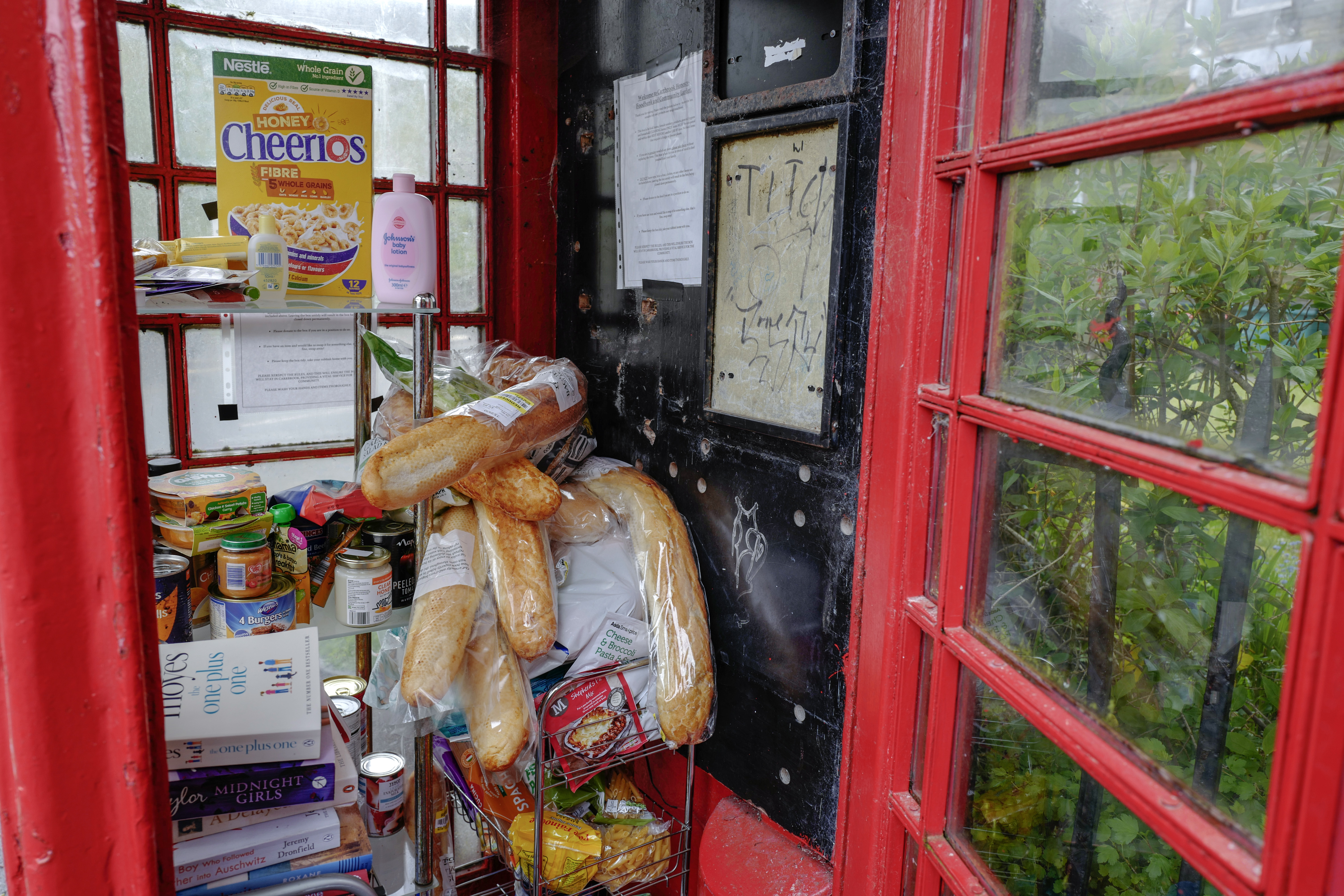A disused traditional red phone box is converted into a free community foodbank