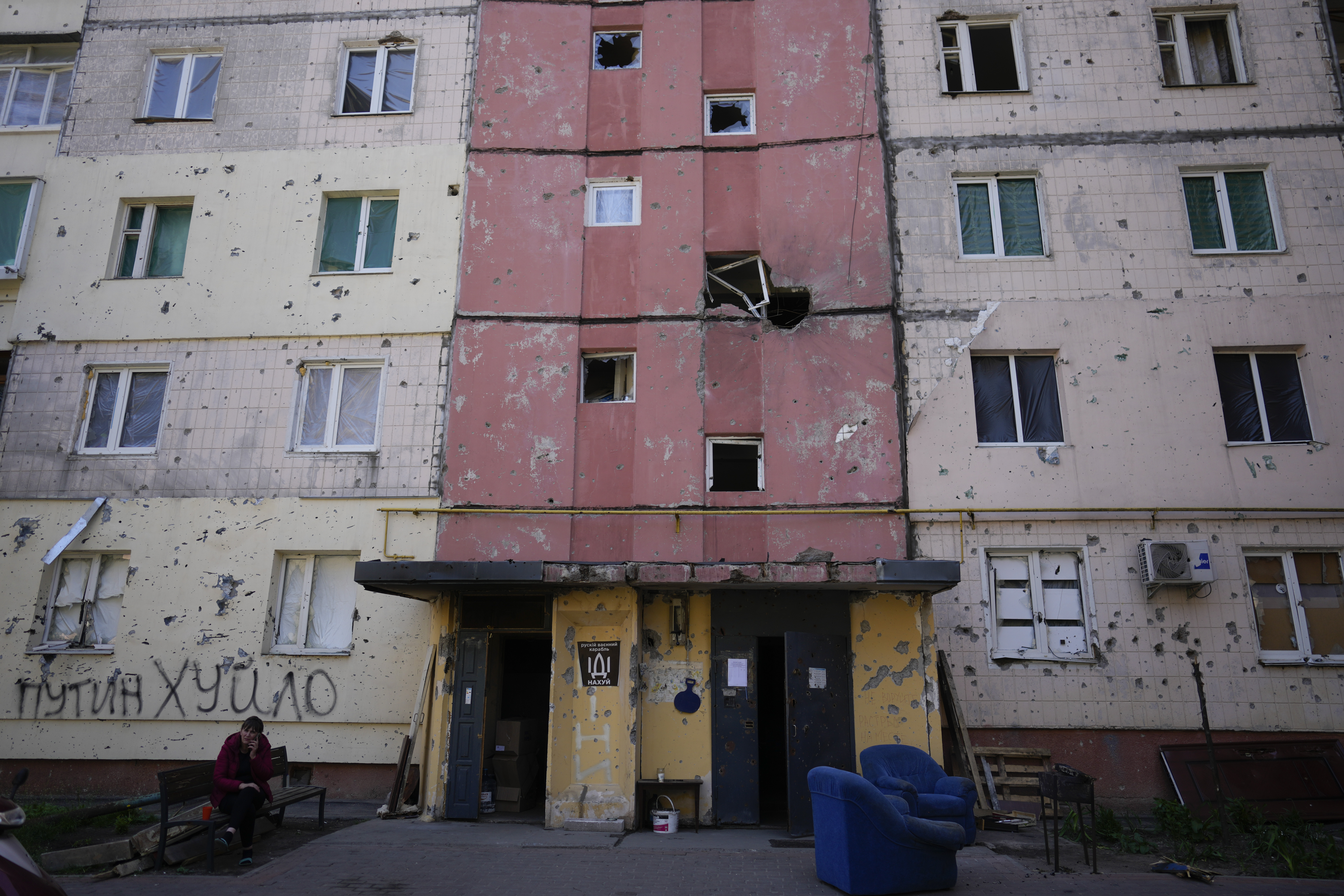 A resident sits outside a house ruined by shelling in Irpin, outskirts of Kyiv, Ukraine, Tuesday, May 24, 2022
