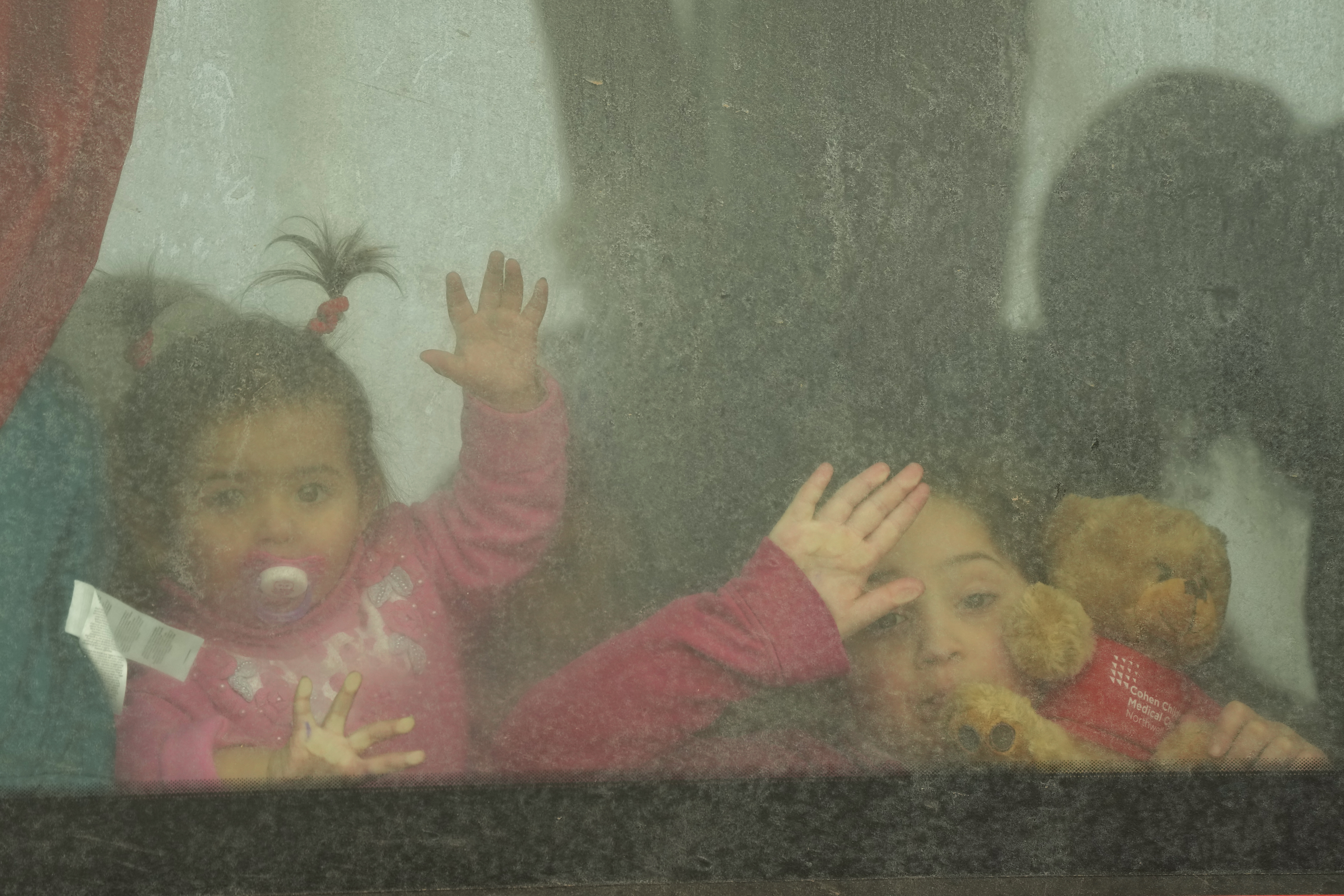 Refugee children look out from a bus leaving to Romania after fleeing the war from neighbouring Ukraine, at the border crossing in Palanca, Moldova, Friday, March 11, 2022