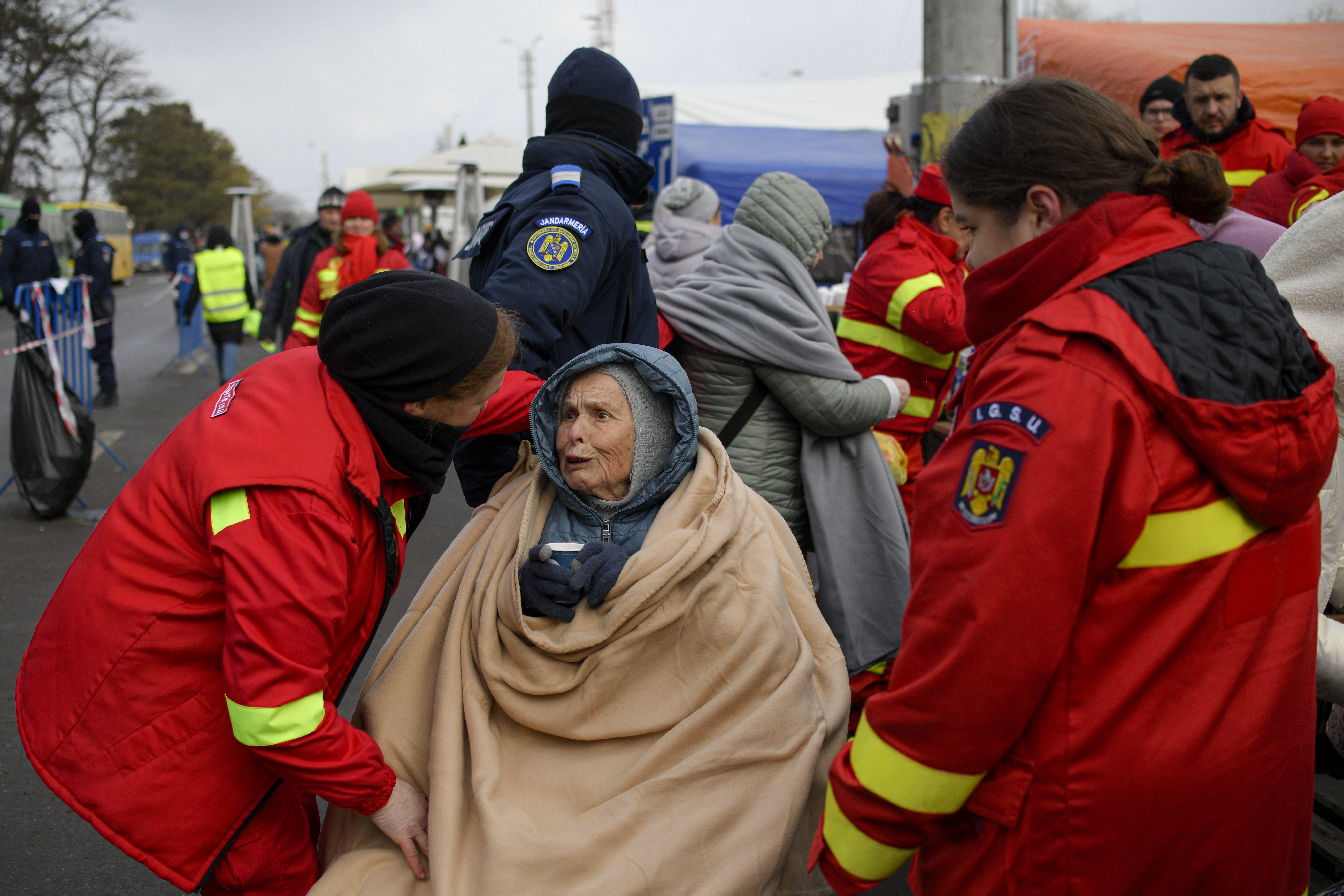 Emergency Situations Department employees talk to wheelchair bound Katia, 90 years-old, a refugee fleeing the conflict from neighbouring Ukraine at the Romanian-Ukrainian border, in Siret, Romania.