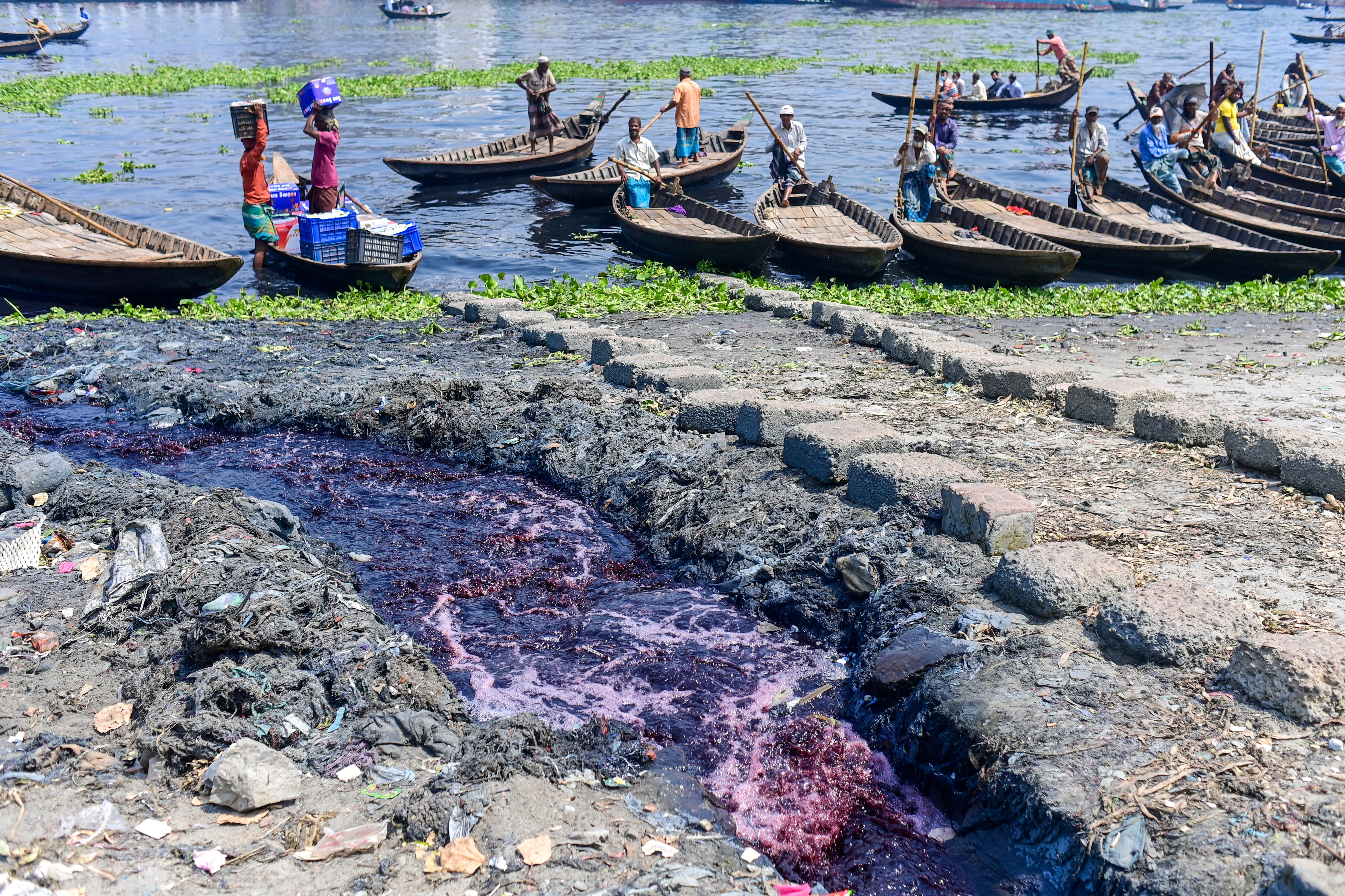 industrial effluents enter the Buriganga River as boatmen wait for passengers in Karanigonj, on the outskirts of Dhaka