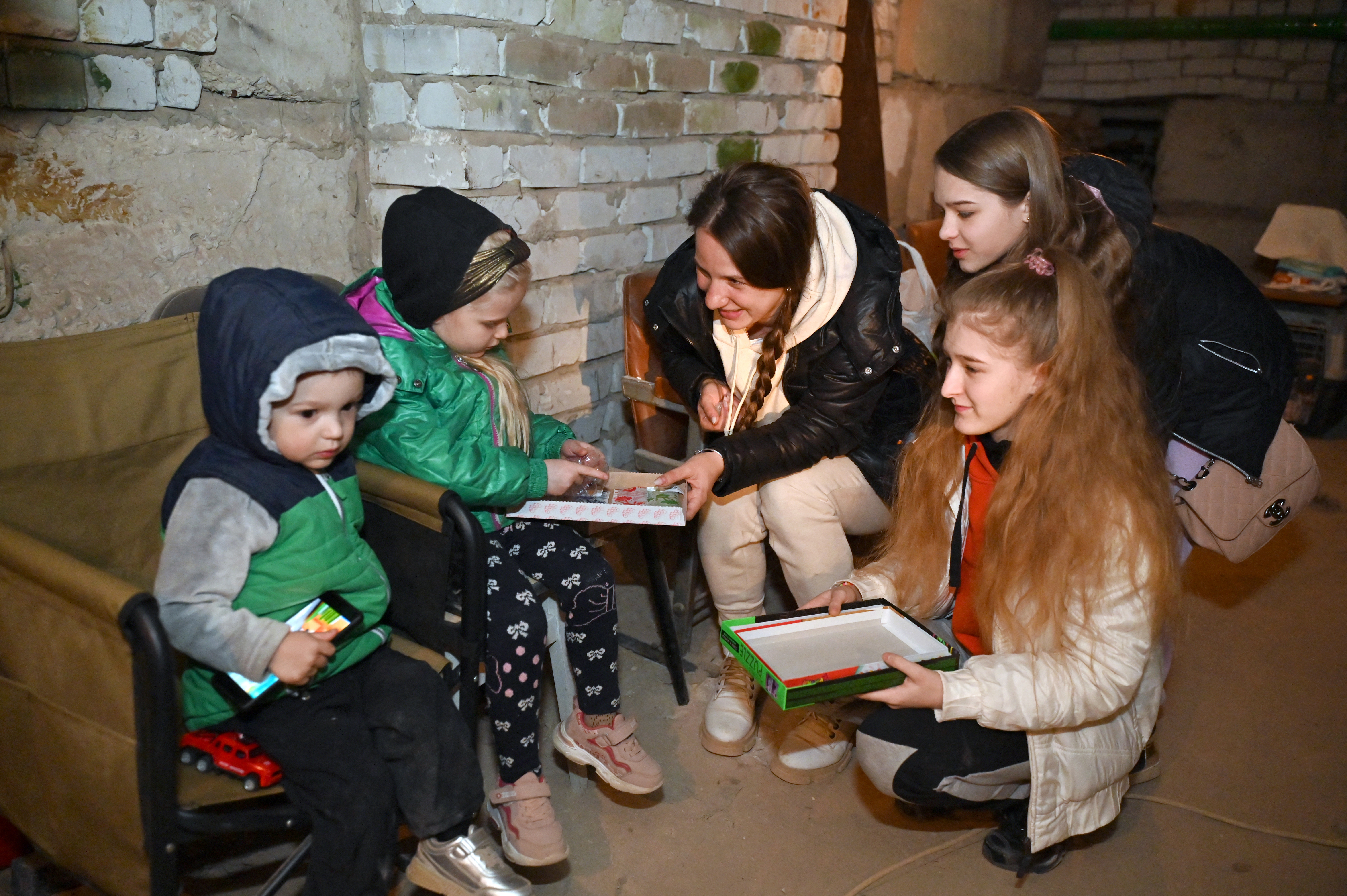 Children play in the basement of a residential building in Kharkiv on March 29, 2022, as they hide from shelling by Russian troops