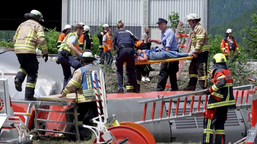 policemen and firemen rescuing a person from a derailed train
