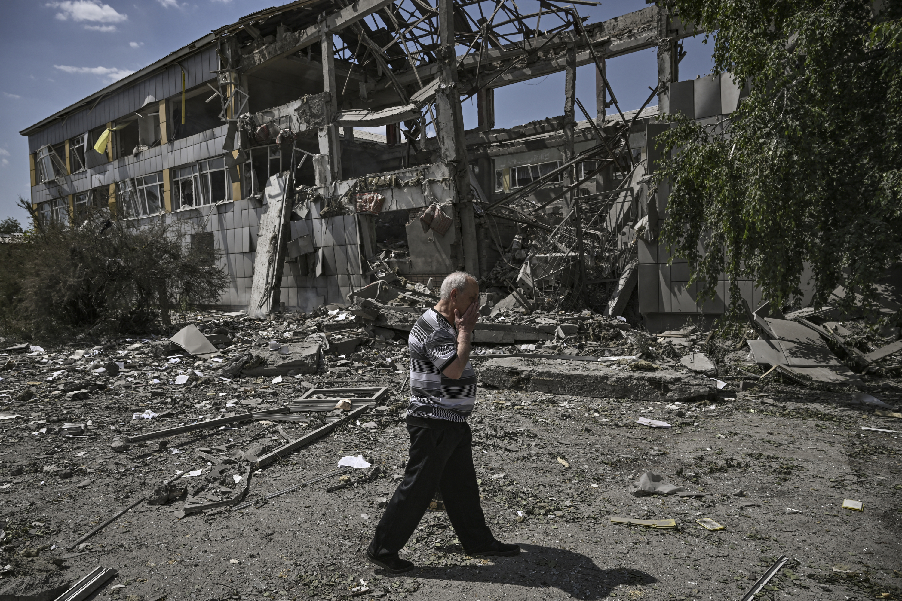 A resident reacts in front of a destroyed school after an attack in the city of Bakhmut, Ukraine.