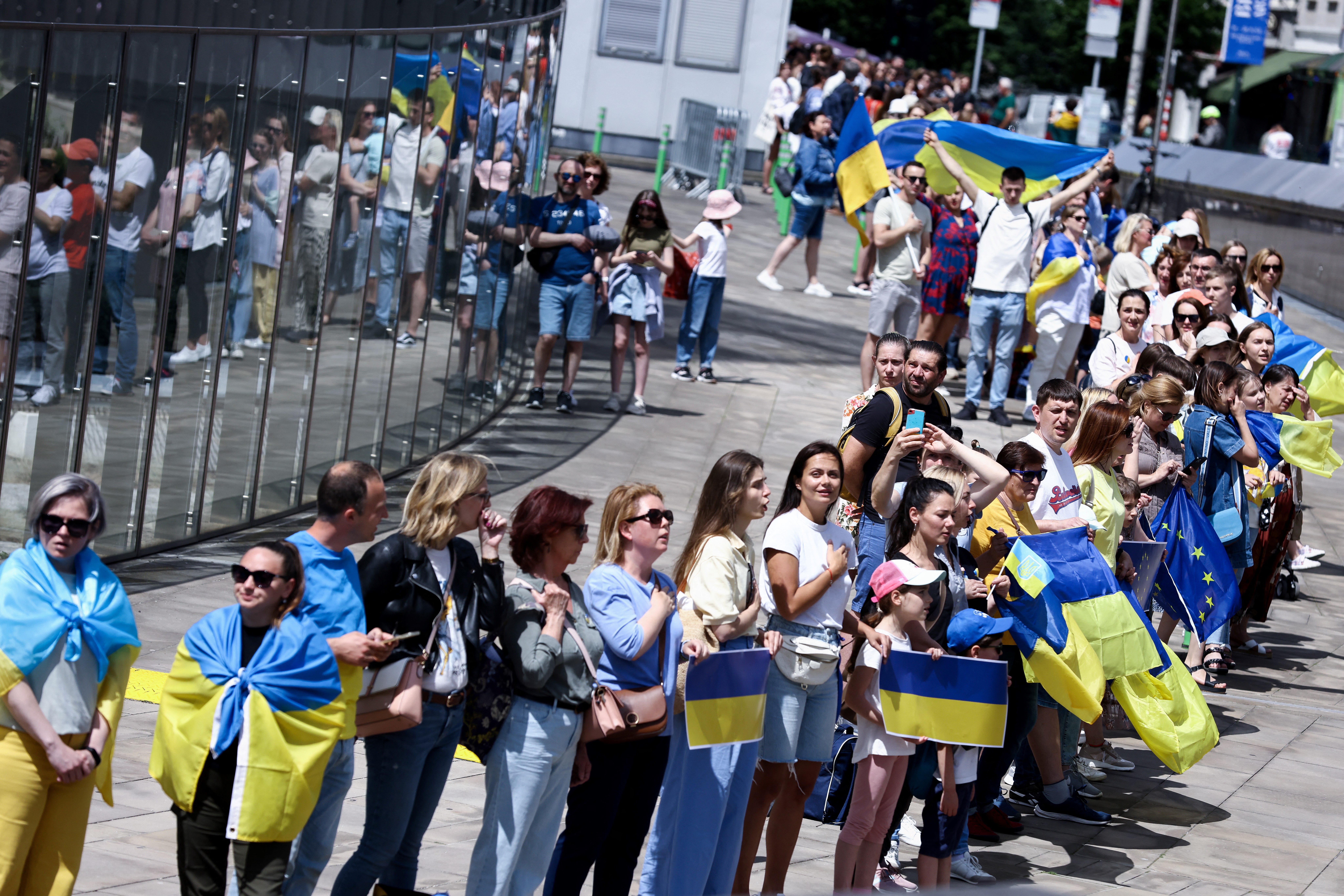 Demonstrators gather during a rally and take part in a human chain around the headquarters of the European Commission
