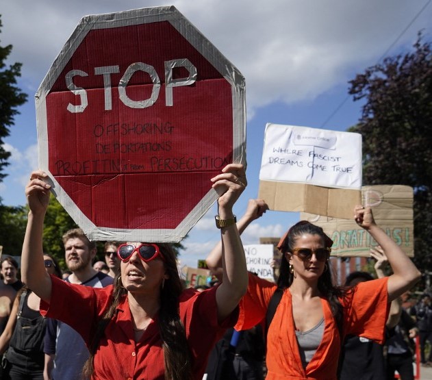 Protesters hold up placards