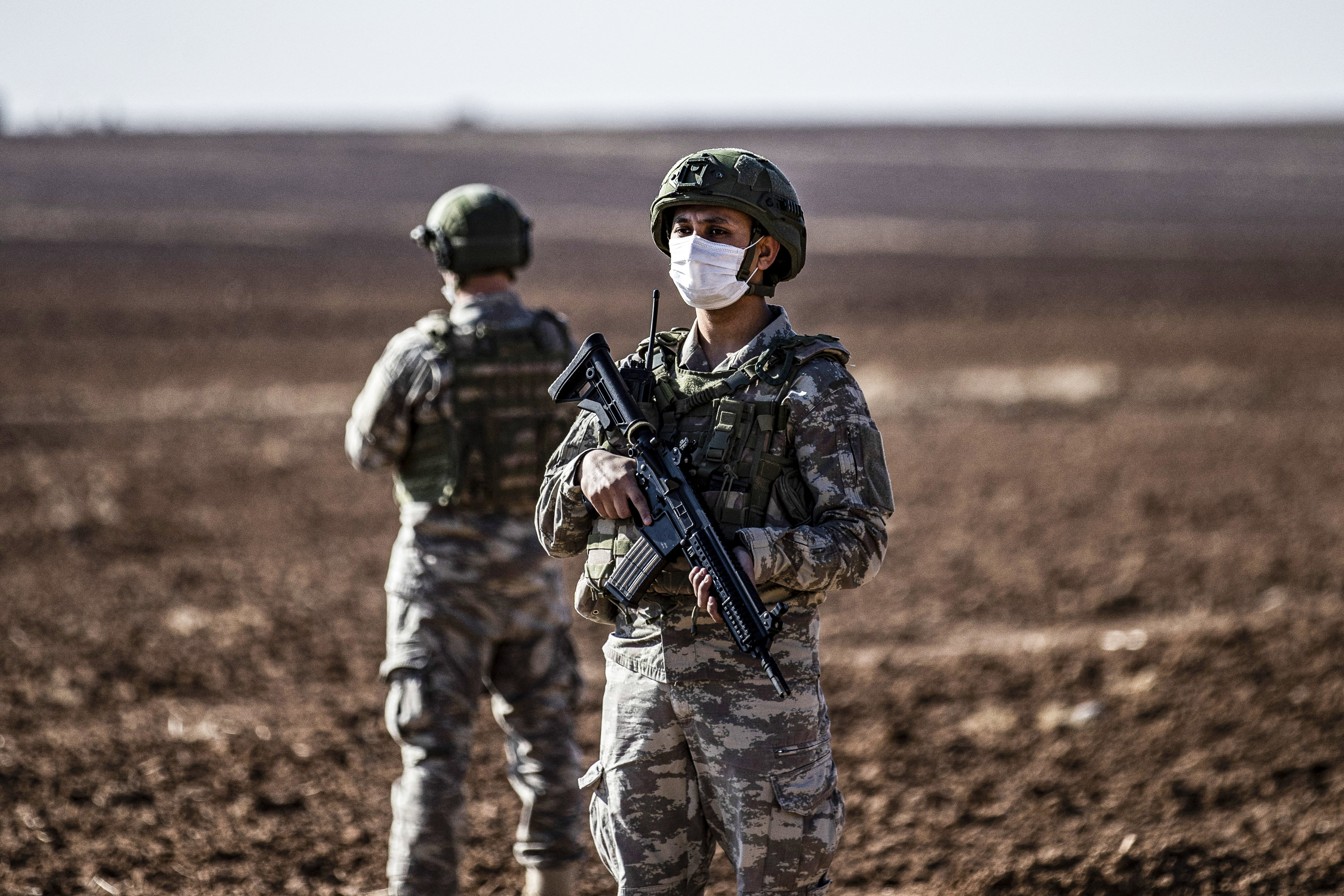 Turkish soldiers stand guard during a joint Russian-Turkish patrol in the eastern countryside of the town of Darbasiyah near the border with Turkey
