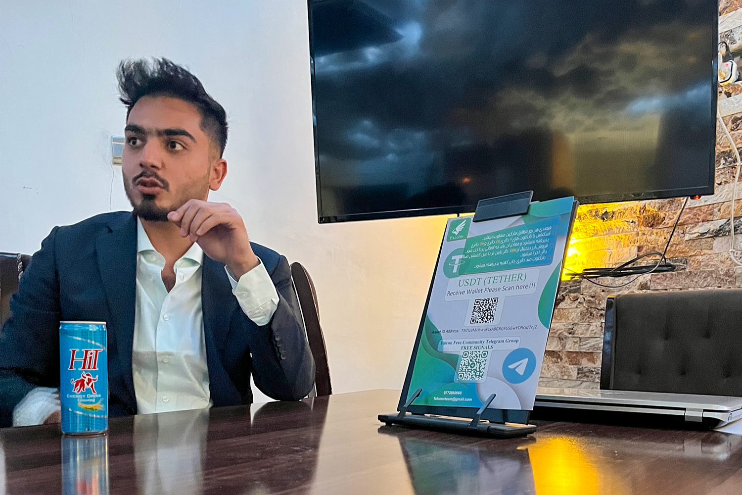 Founder of Falcon Investing Company at a desk in his office in Kabul
